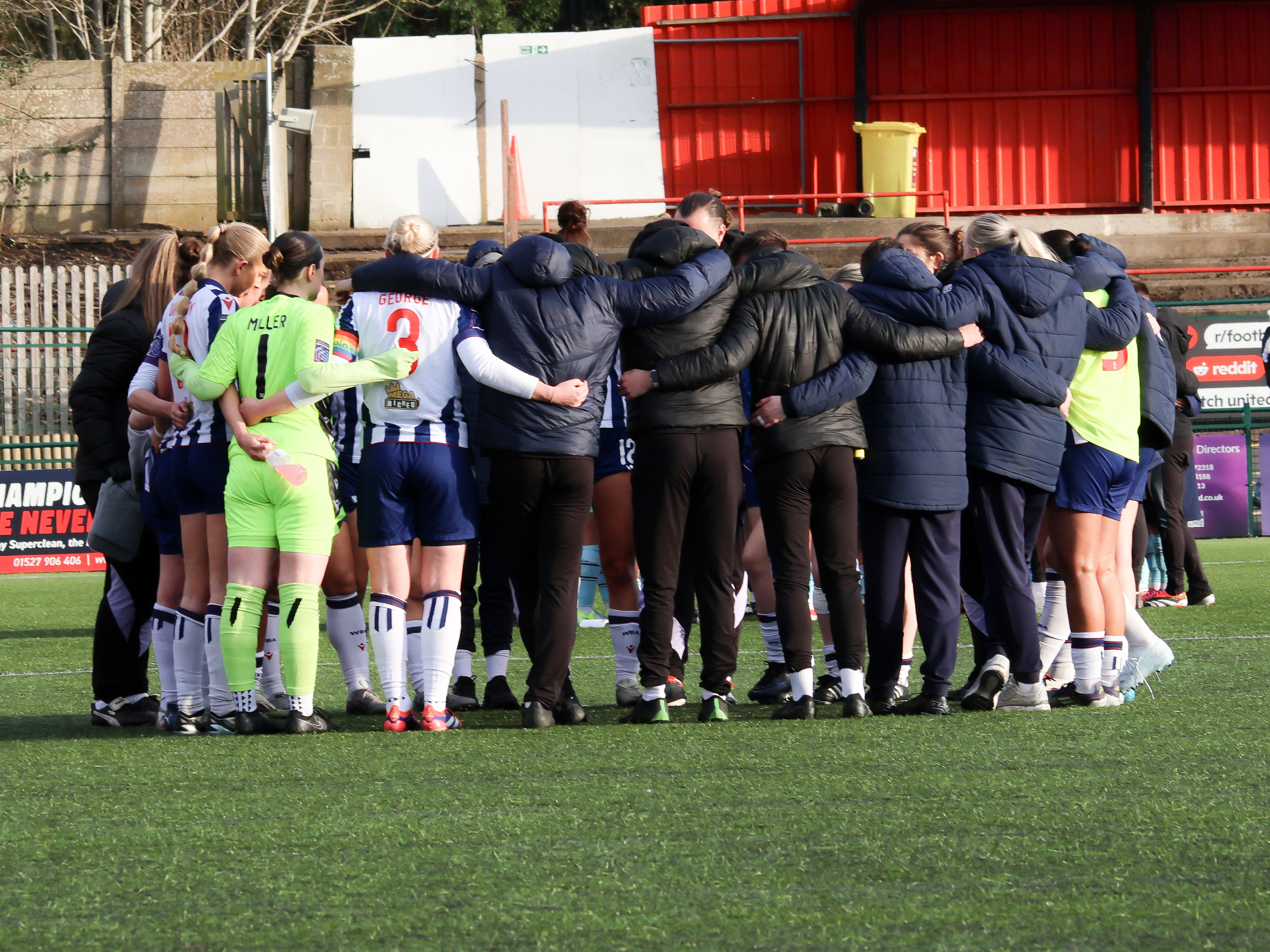 An image of the Albion Women squad in a huddle after their match against Burnley