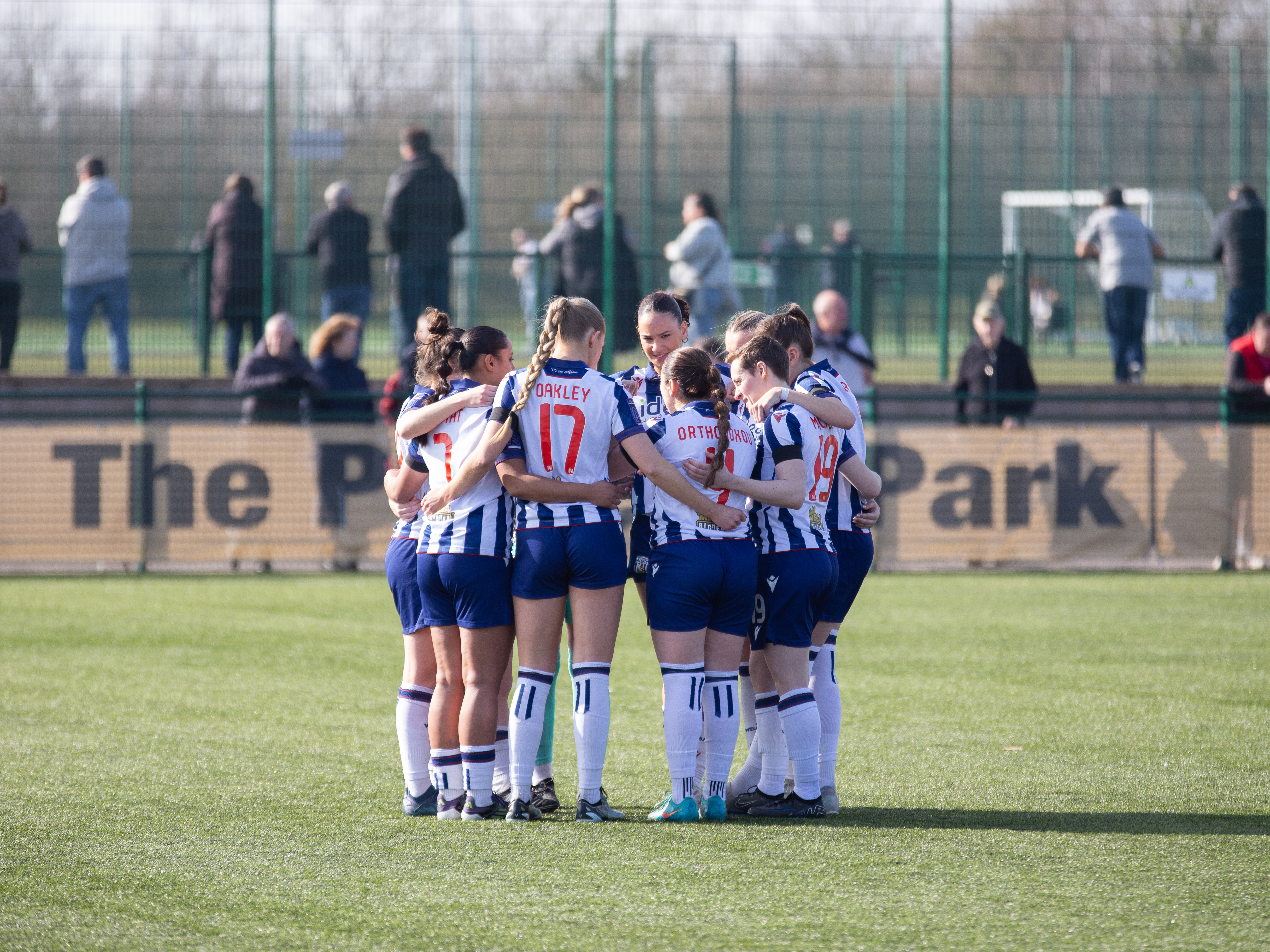 An image of Albion Women in a team huddle before they play Rugby