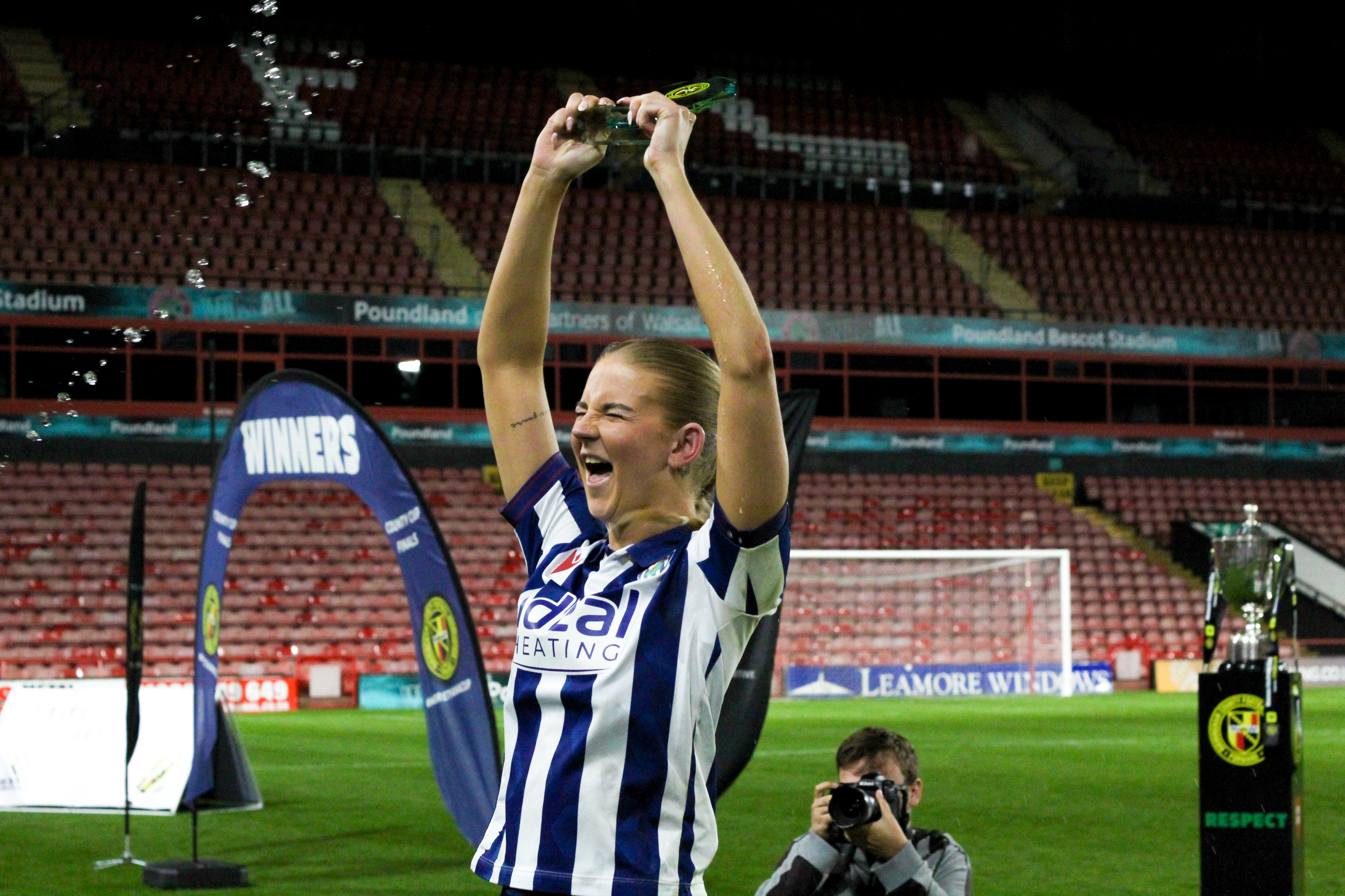 Rhianne Oakley celebrates winning Player of the Match in a cup final in the home kit