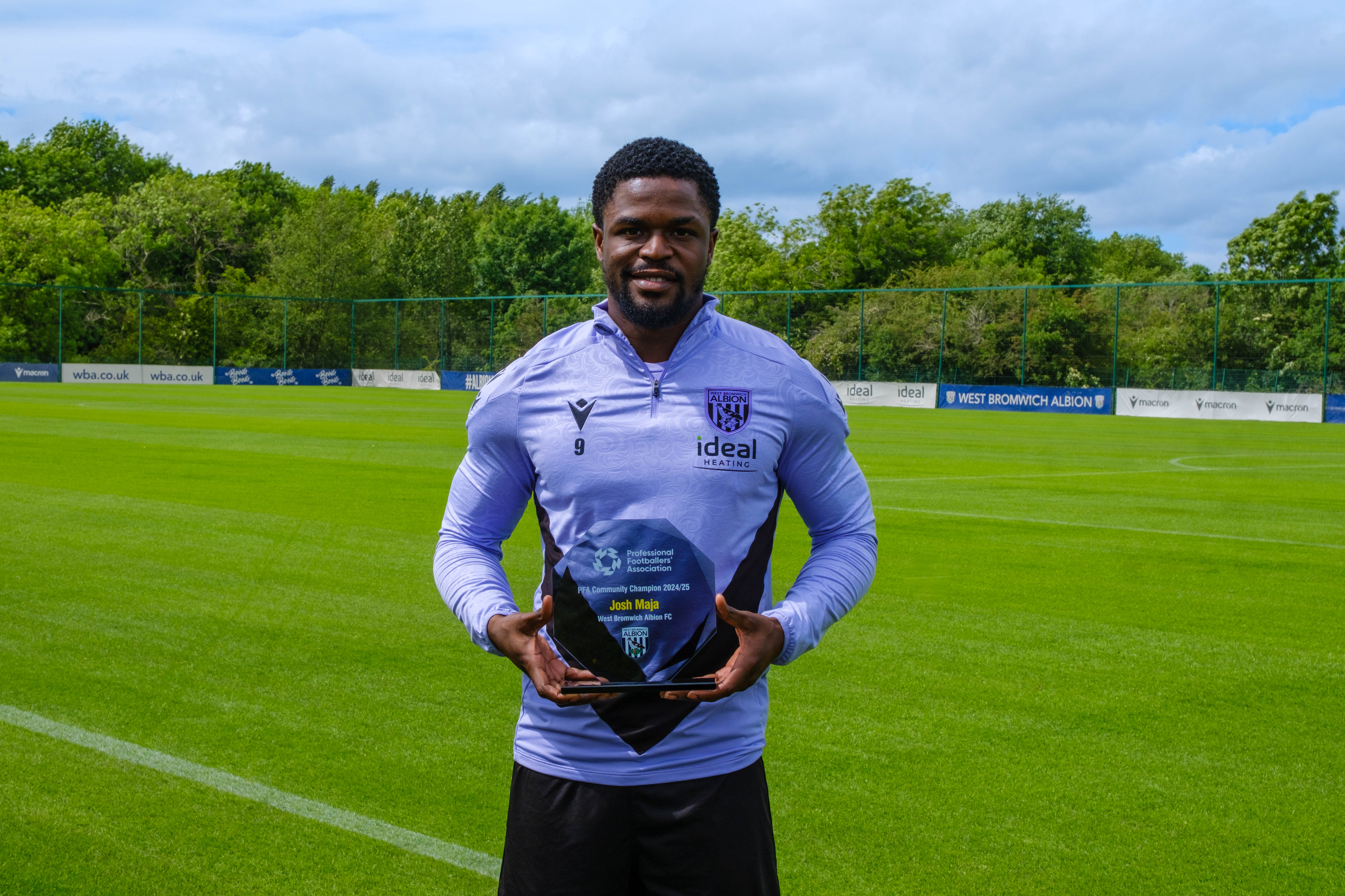 Josh Maja holding this PFA Community Player of the Season award at the training Ground.