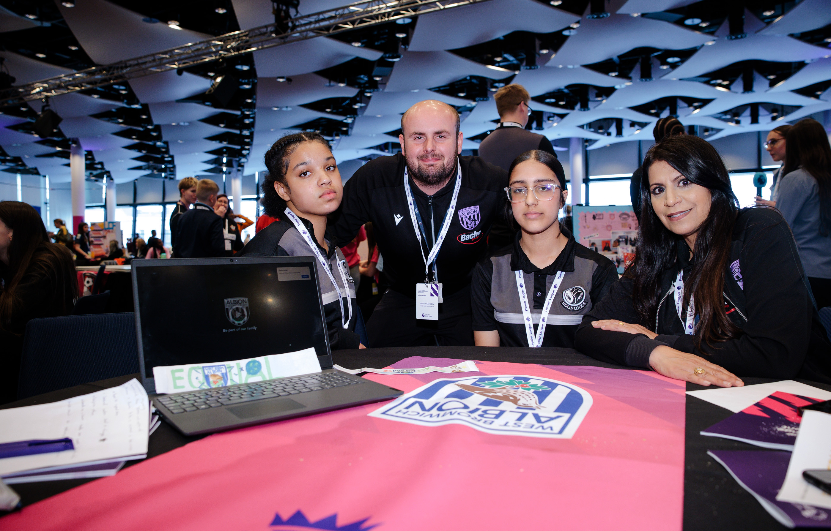 Participants and staff sitting at their presentation table.