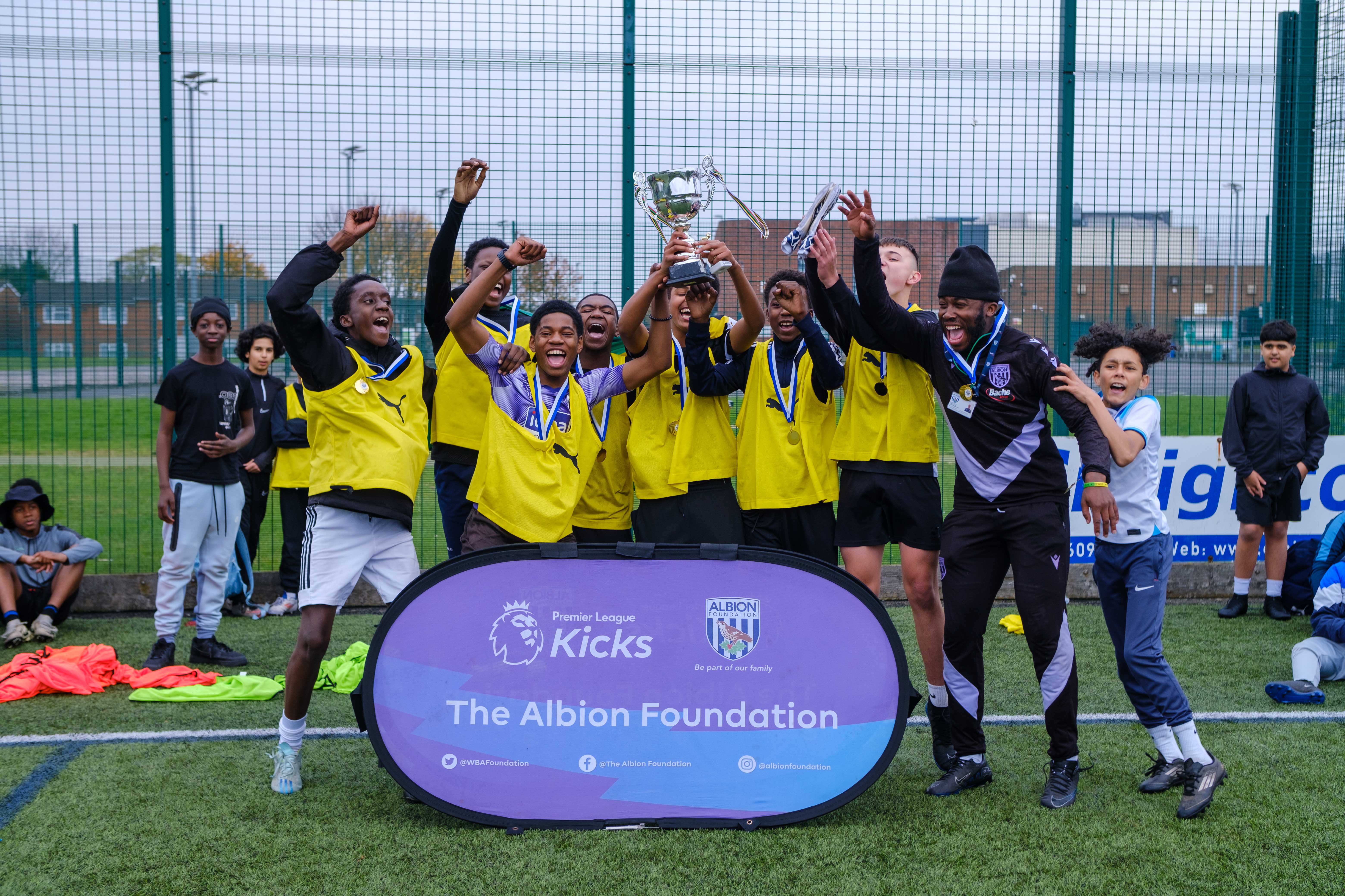 Group of young participants celebrating a trophy lift.