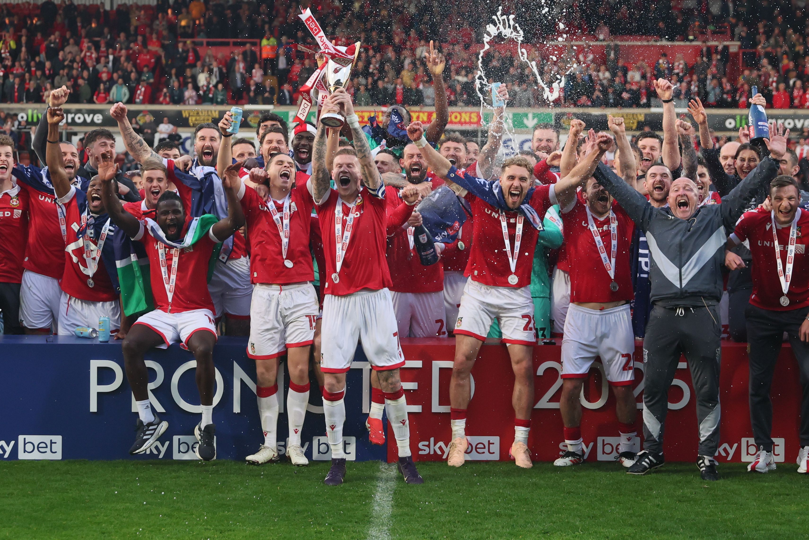 Wrexham celebrate promotion by cheering and spraying champagne