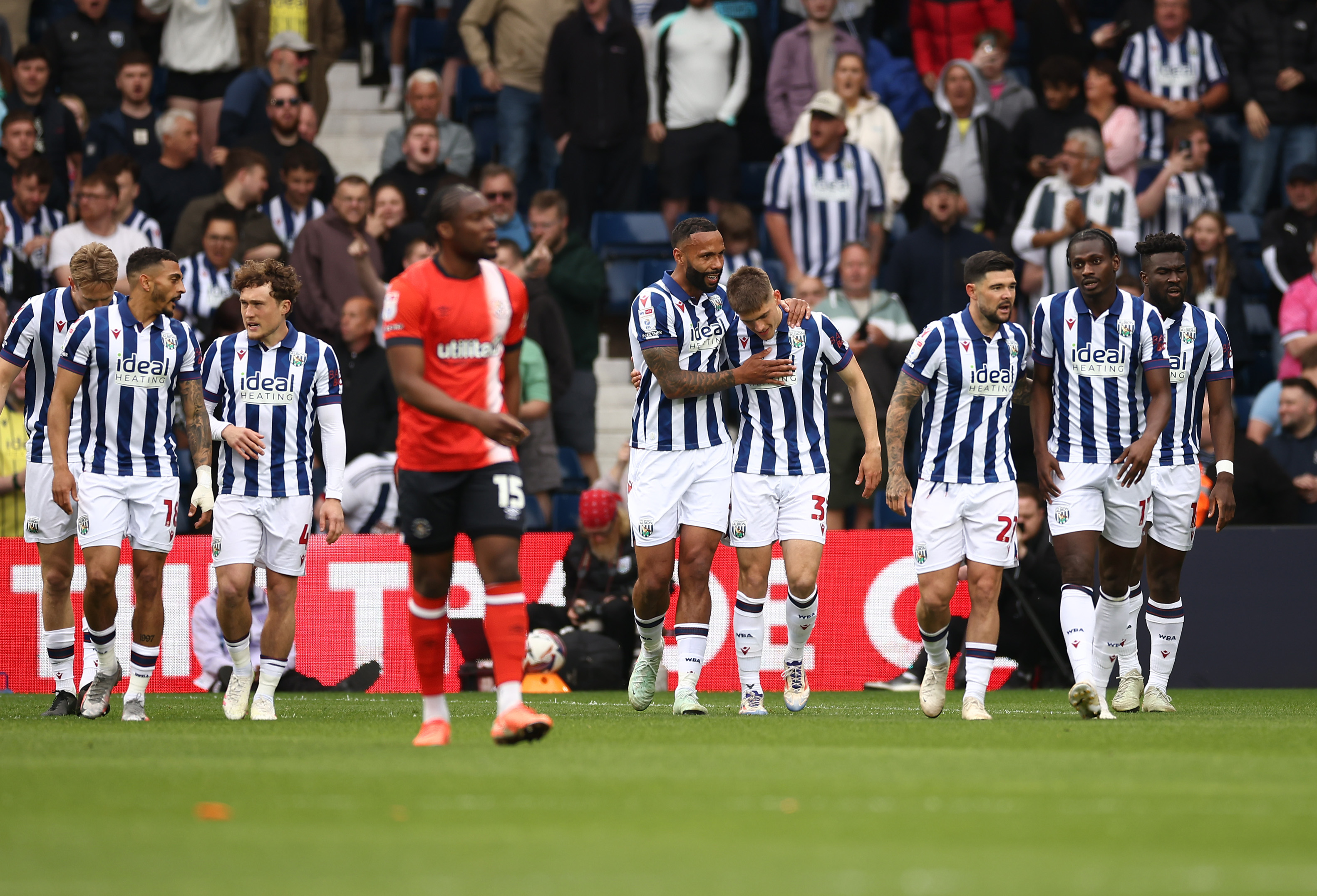 Tom Fellows celebrates with team-mates after scoring against Luton Town
