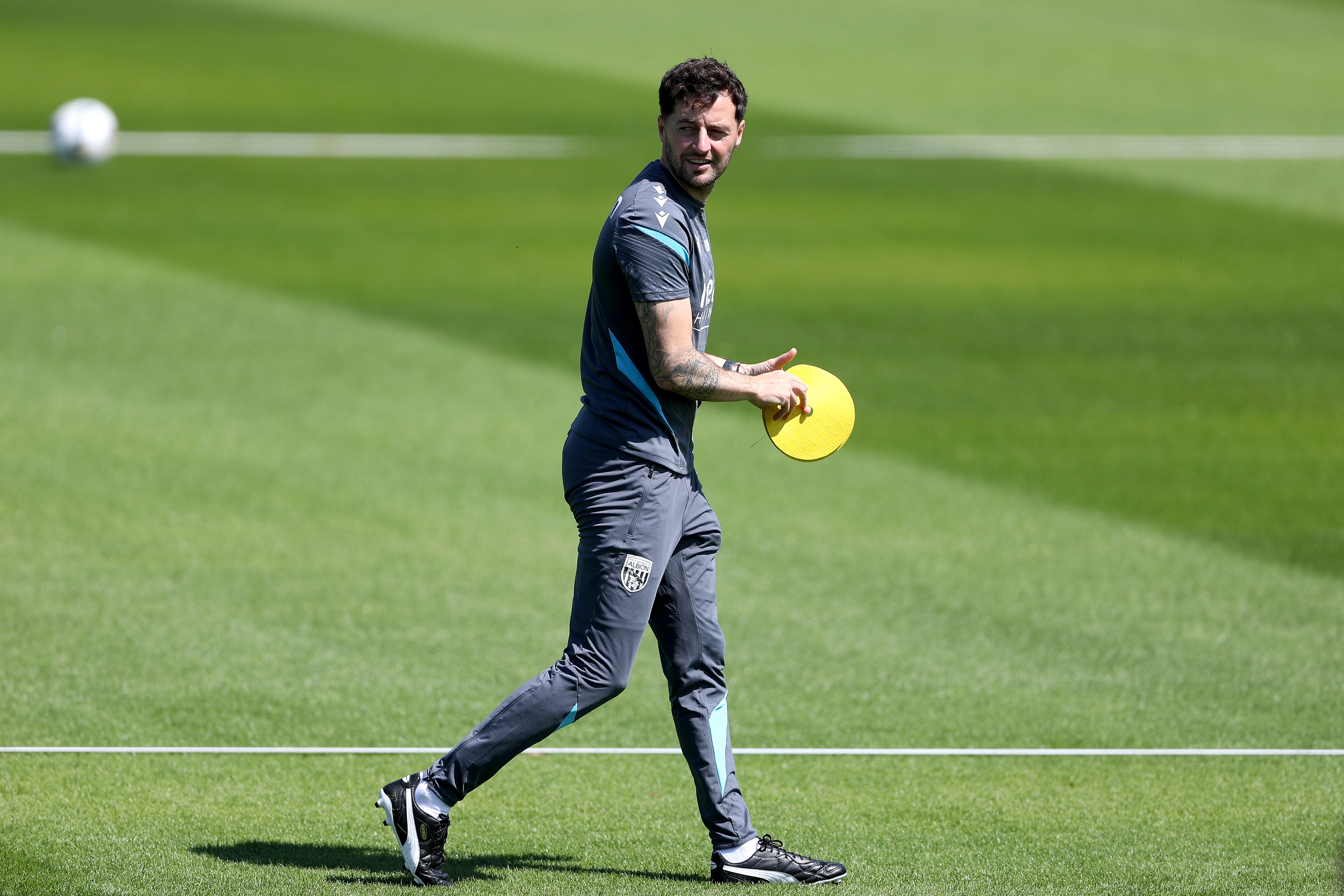 Ryan Mason walking during a training session with a cone in his hand