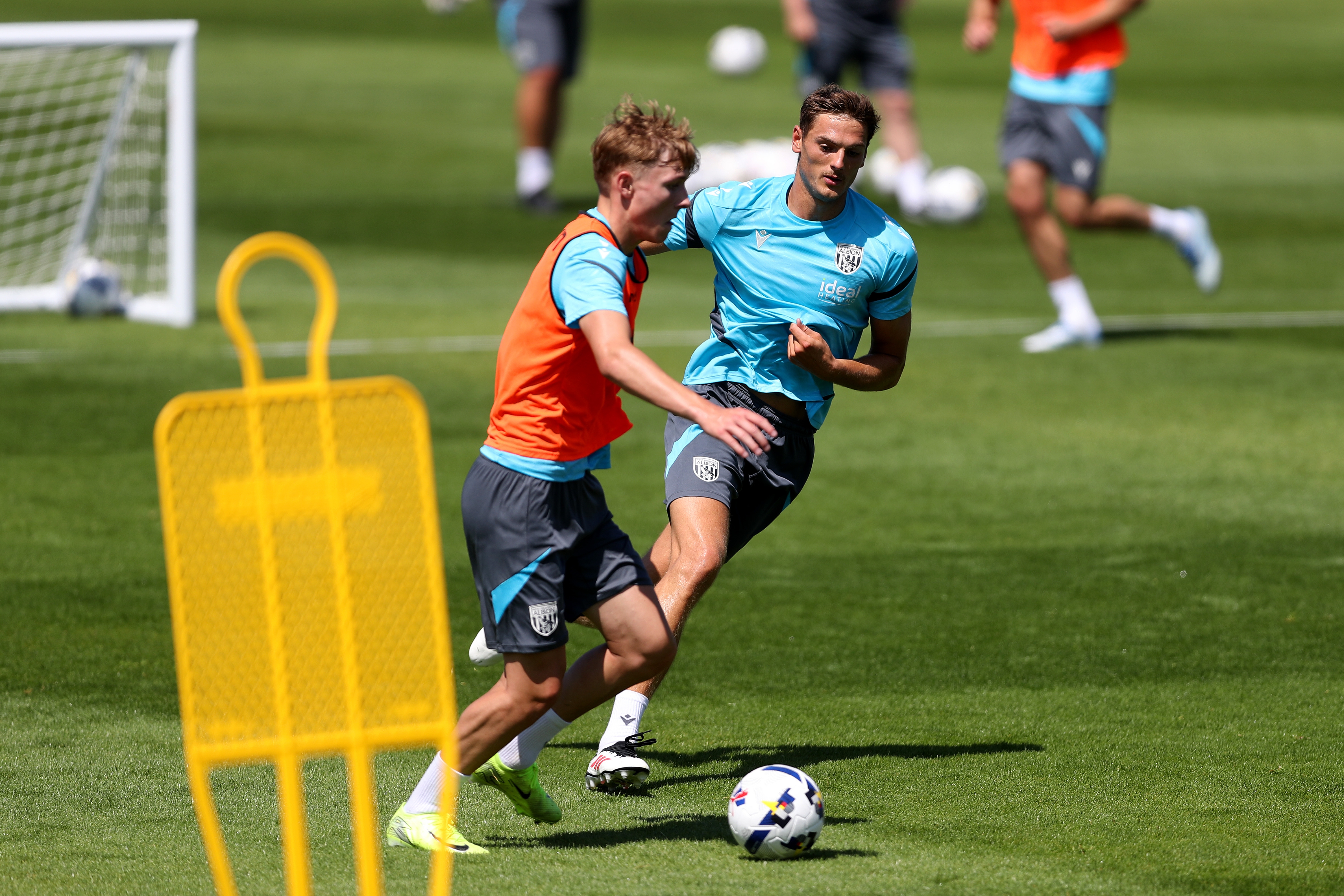 Ollie Bostock on the ball during training with Caleb Taylor closing him down
