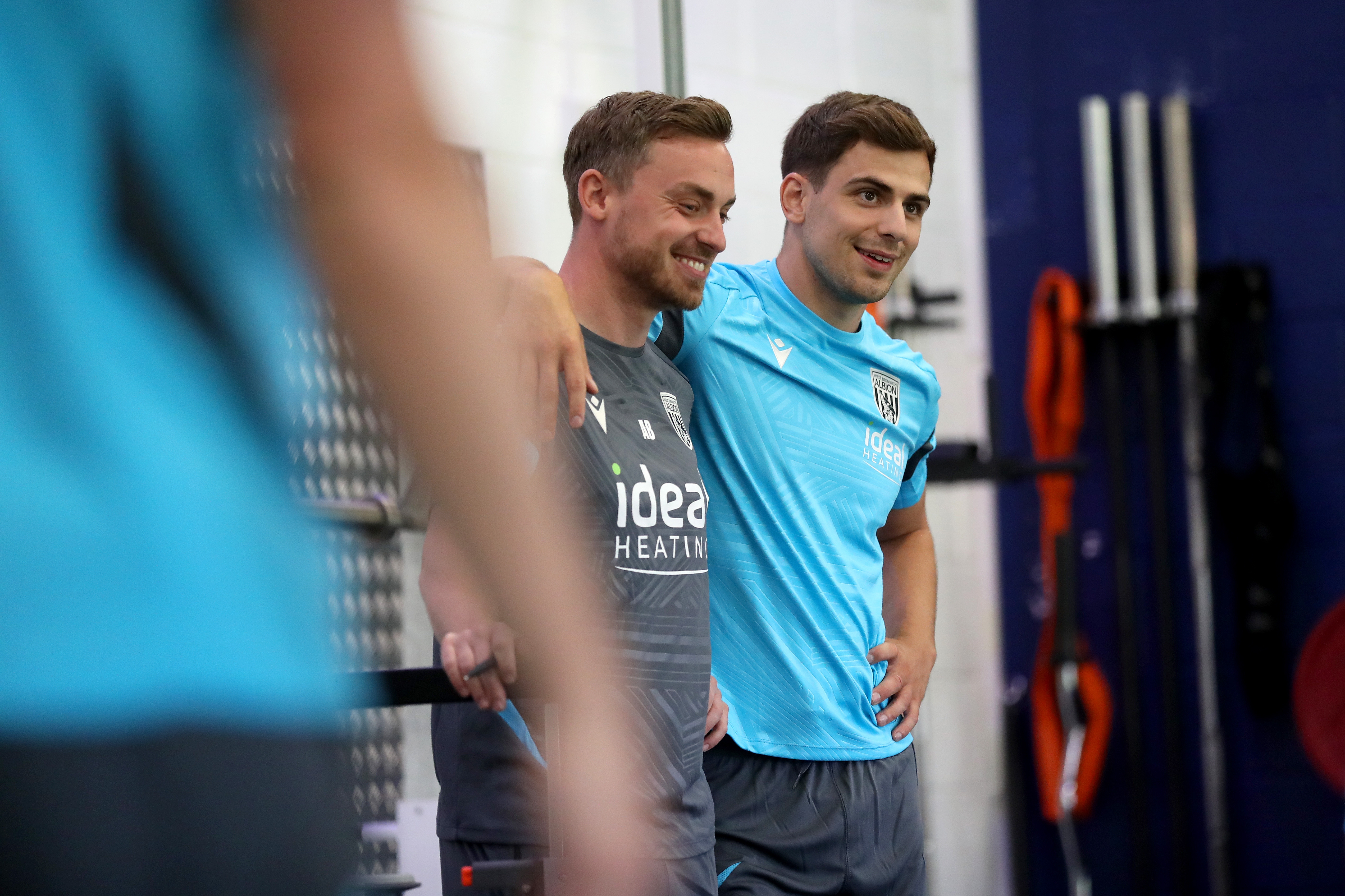 Jayson Molumby with his arm around a member of staff smiling in the gym