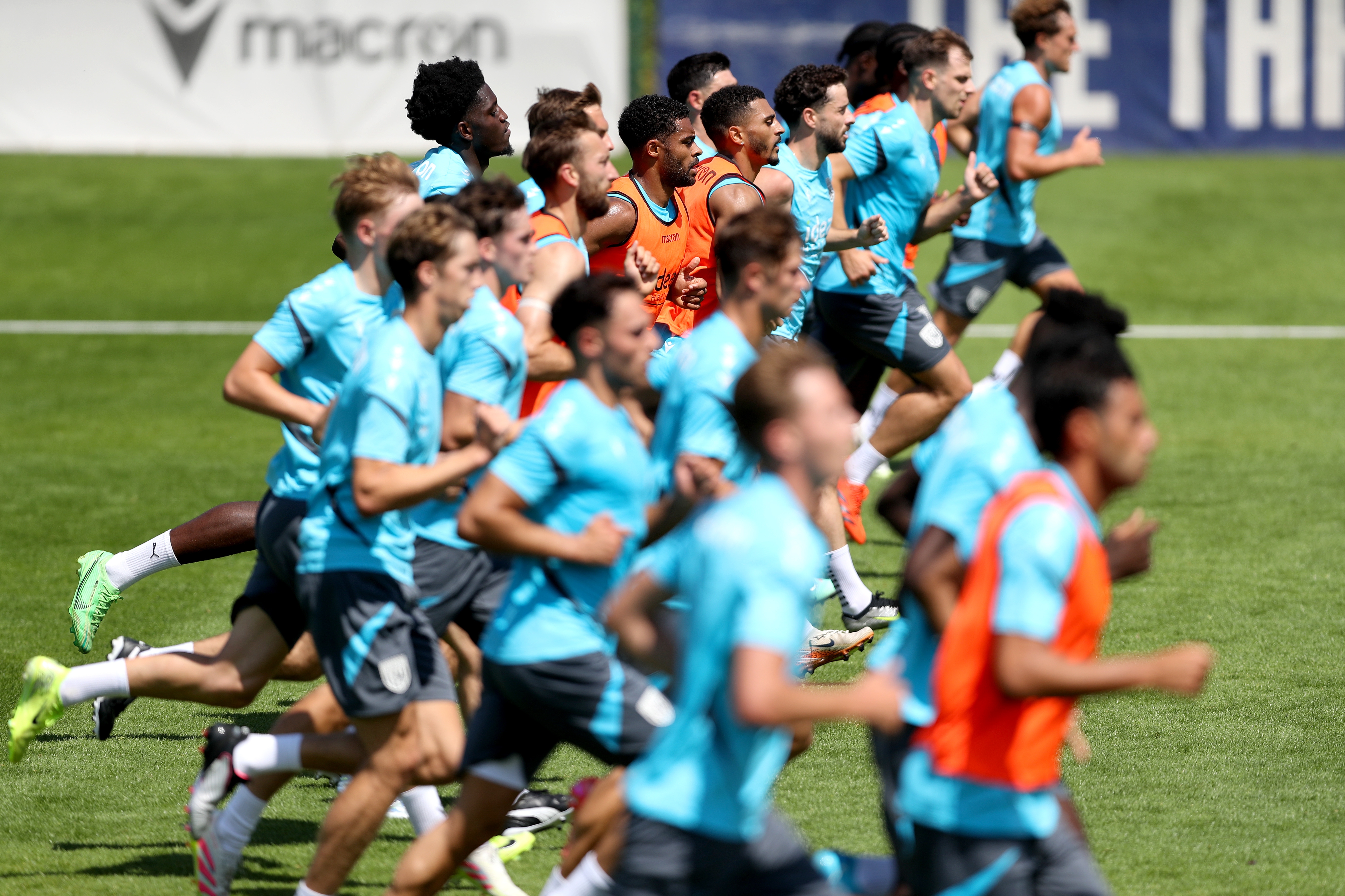 the first-team squad in a line running forward during a training session