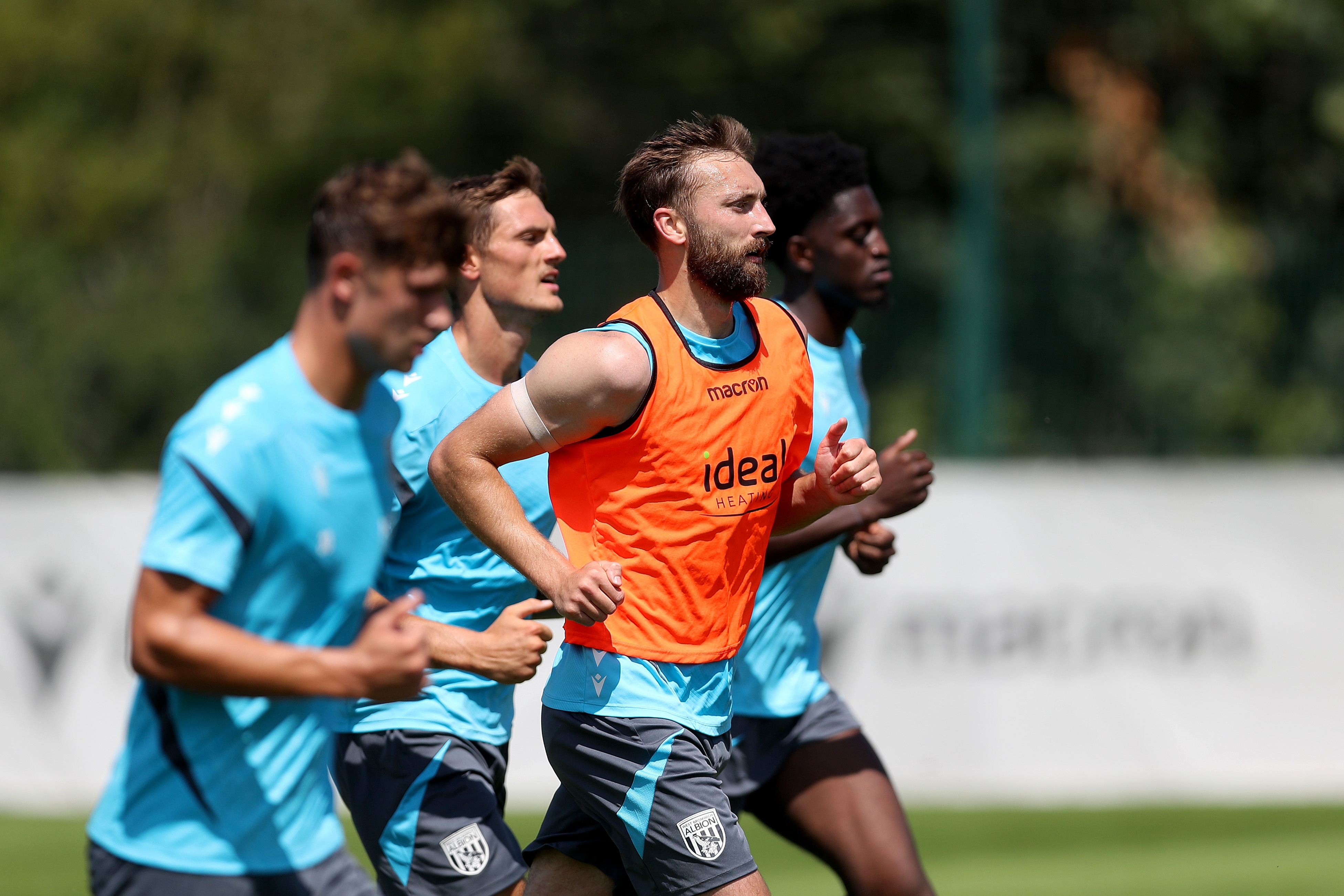 Nat Phillips and three team-mates running forward during a training session