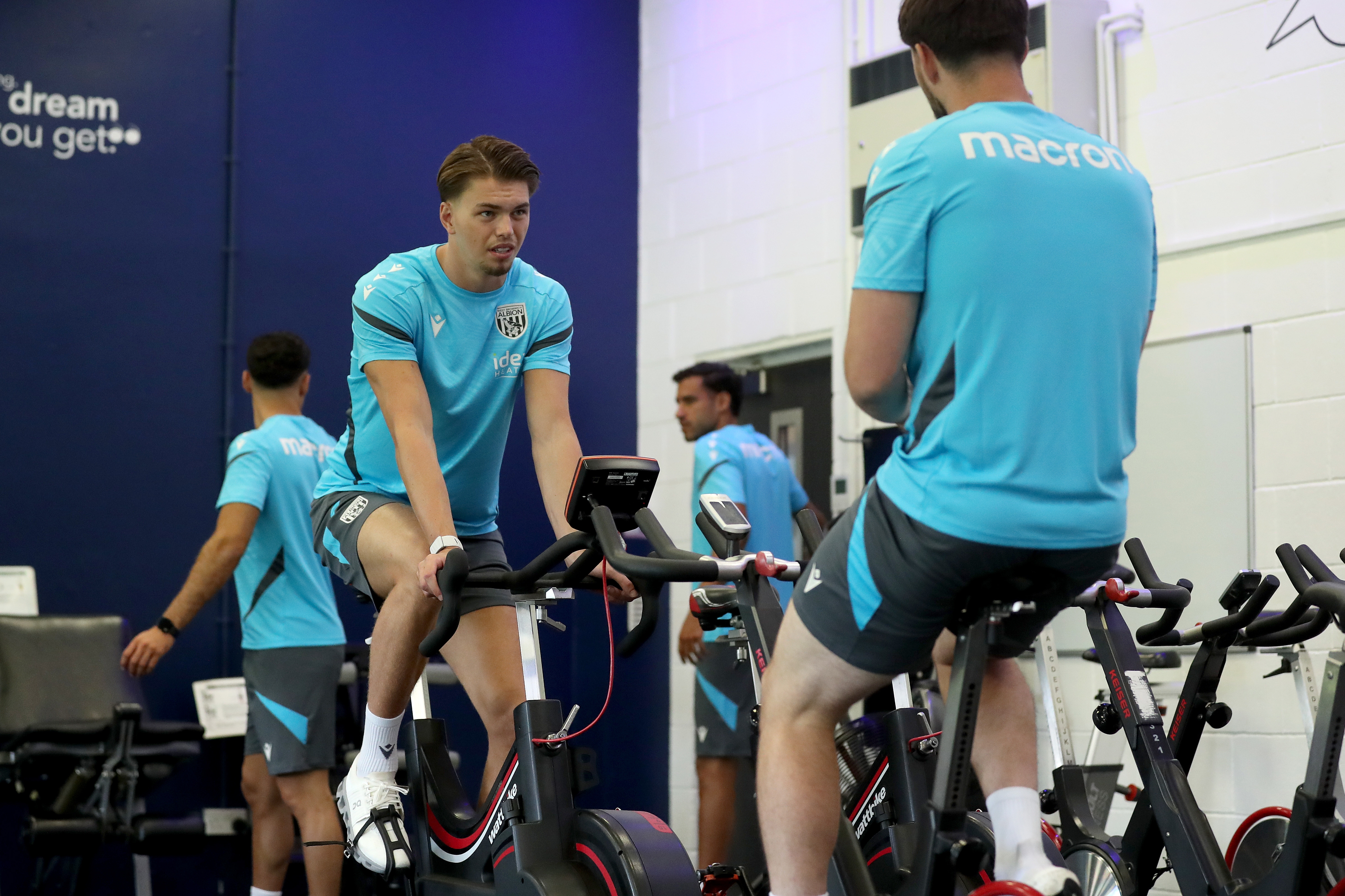Josh Griffiths and Joe Wildsmith sat on exercise bikes chatting in the gym