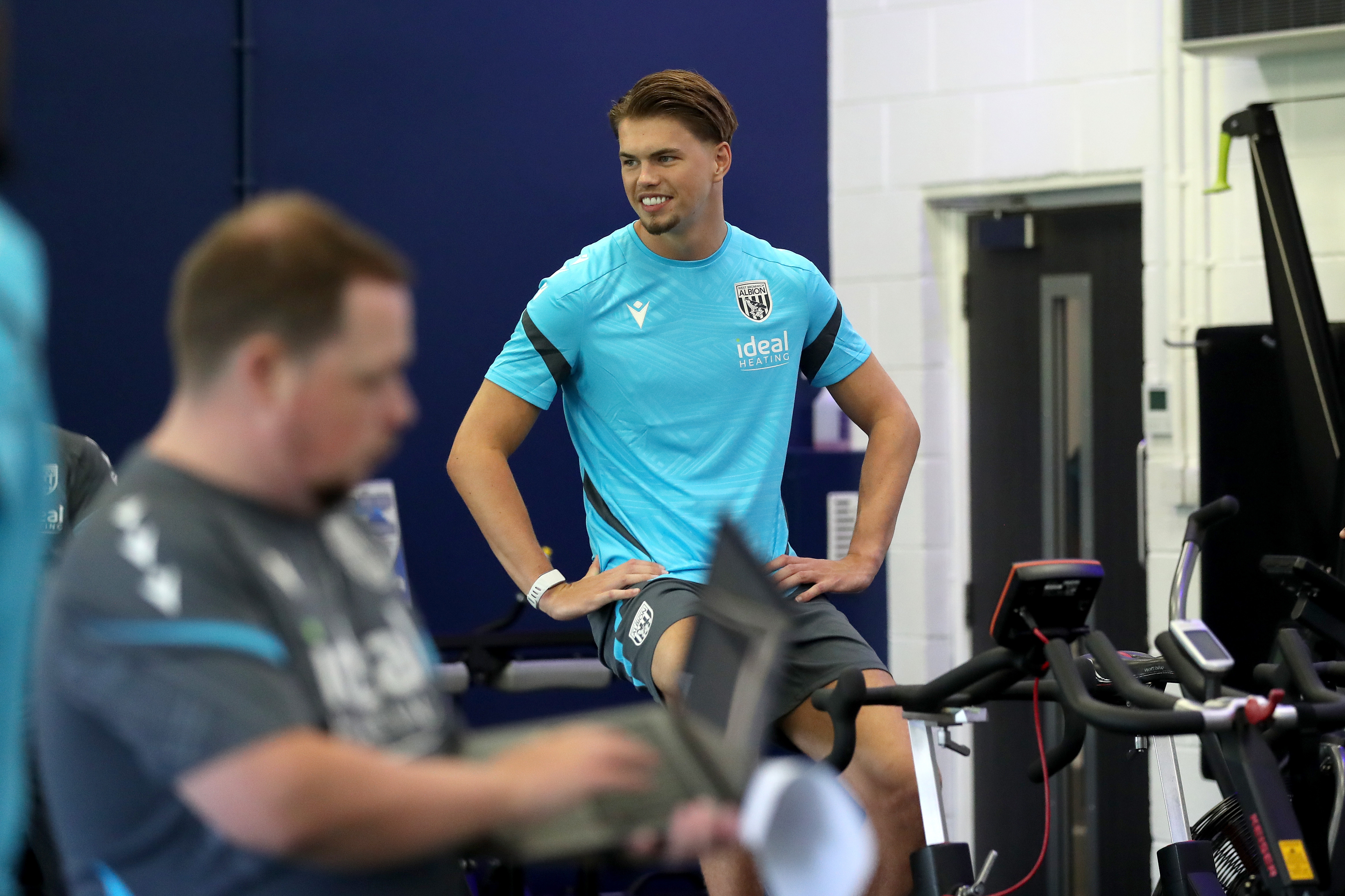 Josh Griffiths sat on an exercise bike in the gym smiling 