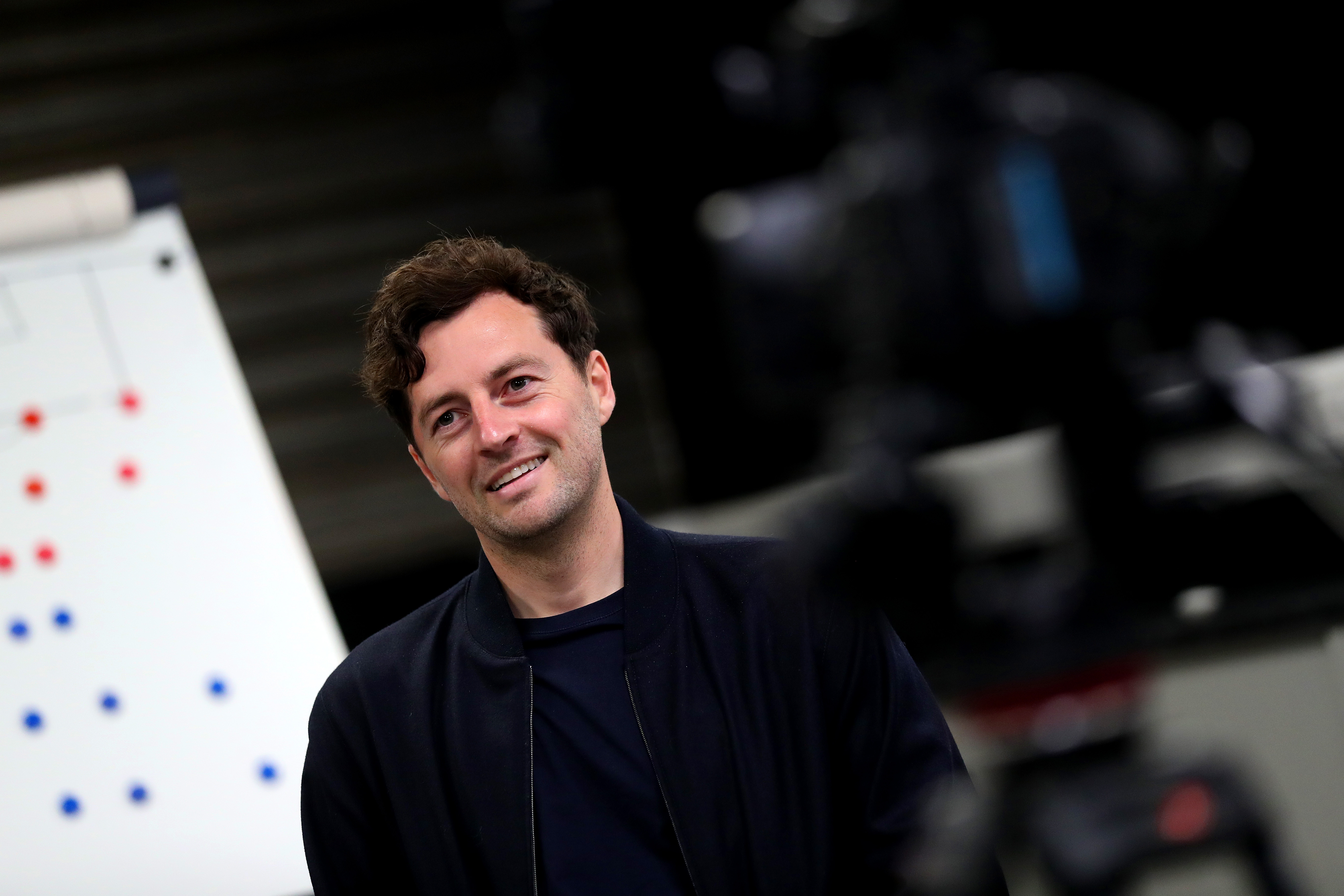 Ryan Mason smiling while being interviewed in front of a tactics board
