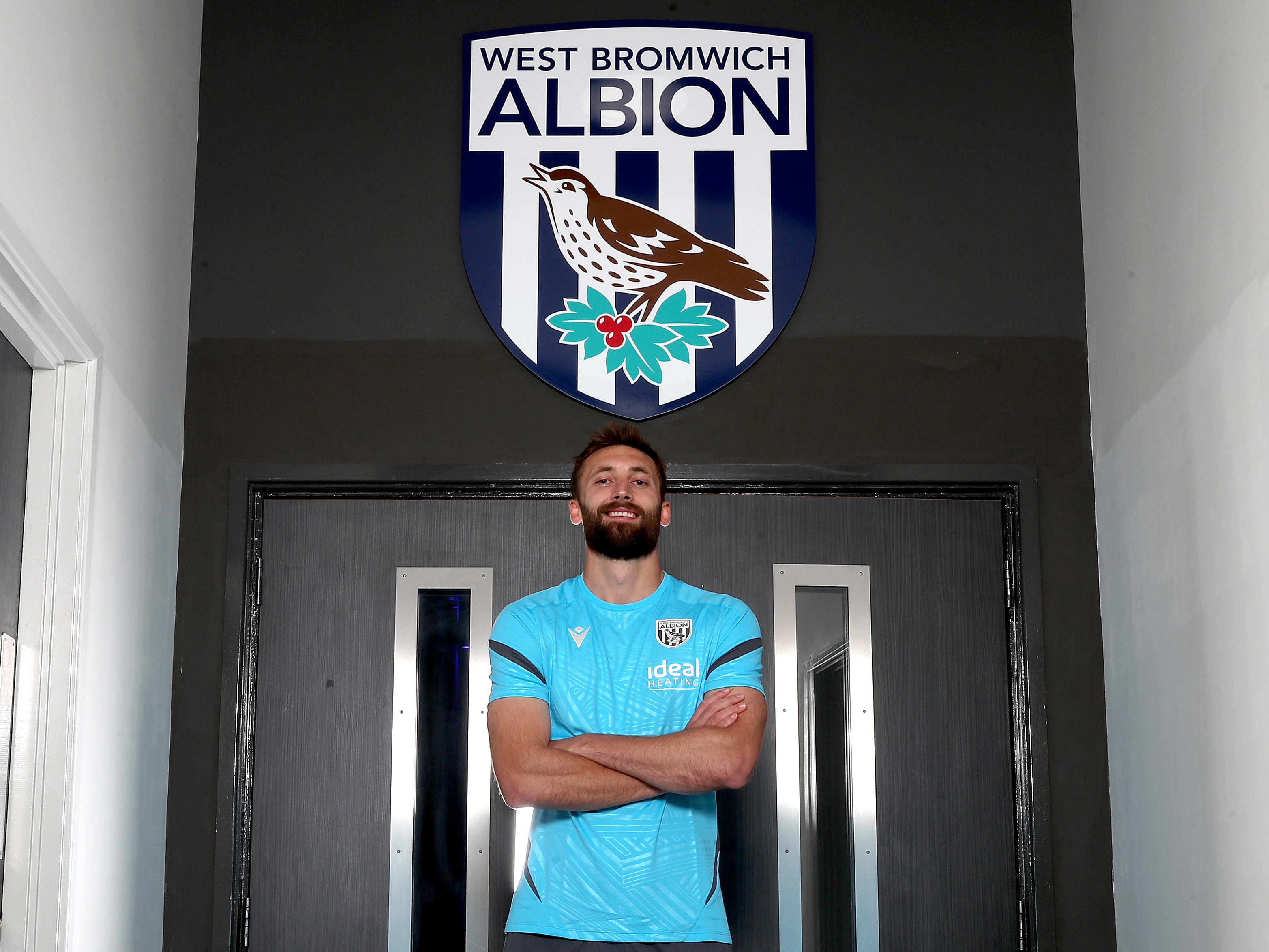 A photo of Nat Phillips standing in front of the Albion badge inside the club training ground
