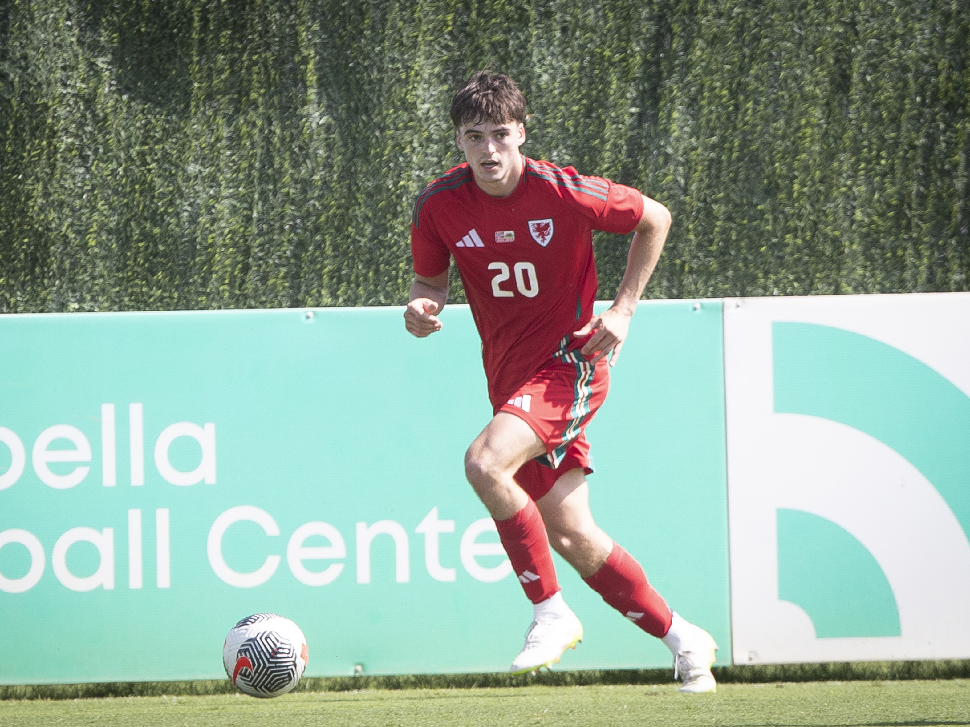 A photo of Albion U21 defender Alex Williams playing for Wales in their red kit