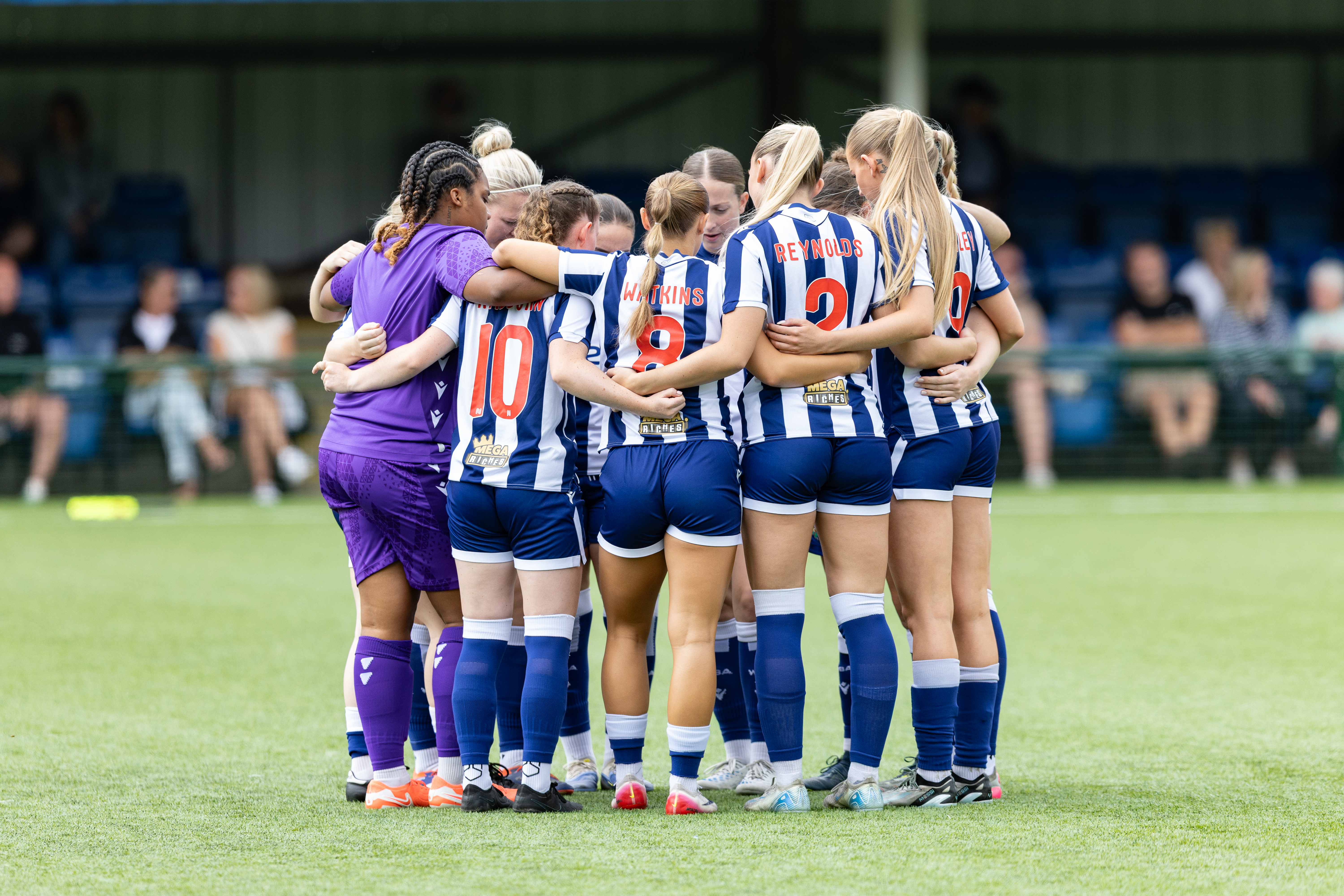 Albion Women in a team huddle before a game wearing the home kit