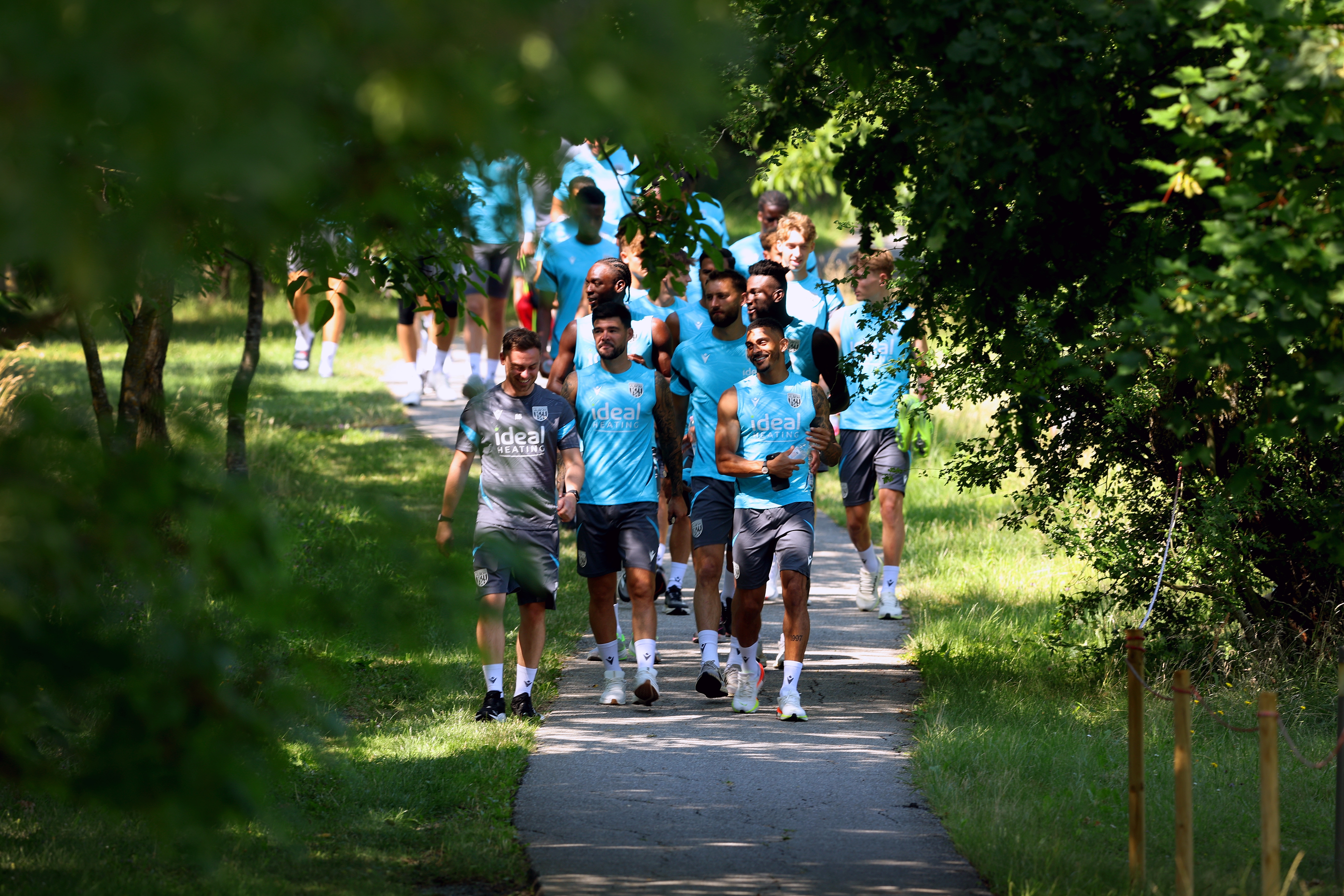 Albion players walking down a path heading to training 