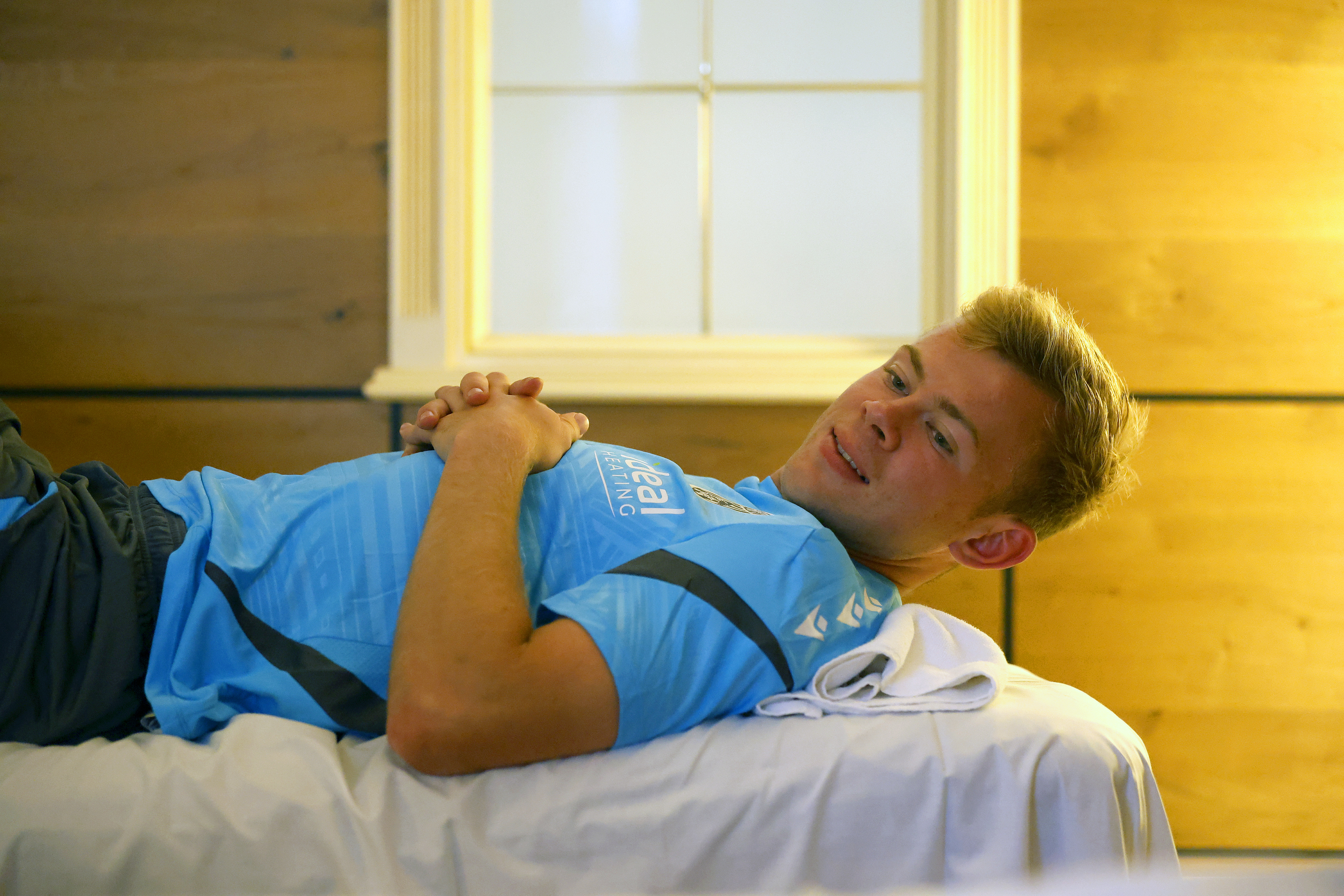 Aune Heggebø smiling while lying on a medical bed
