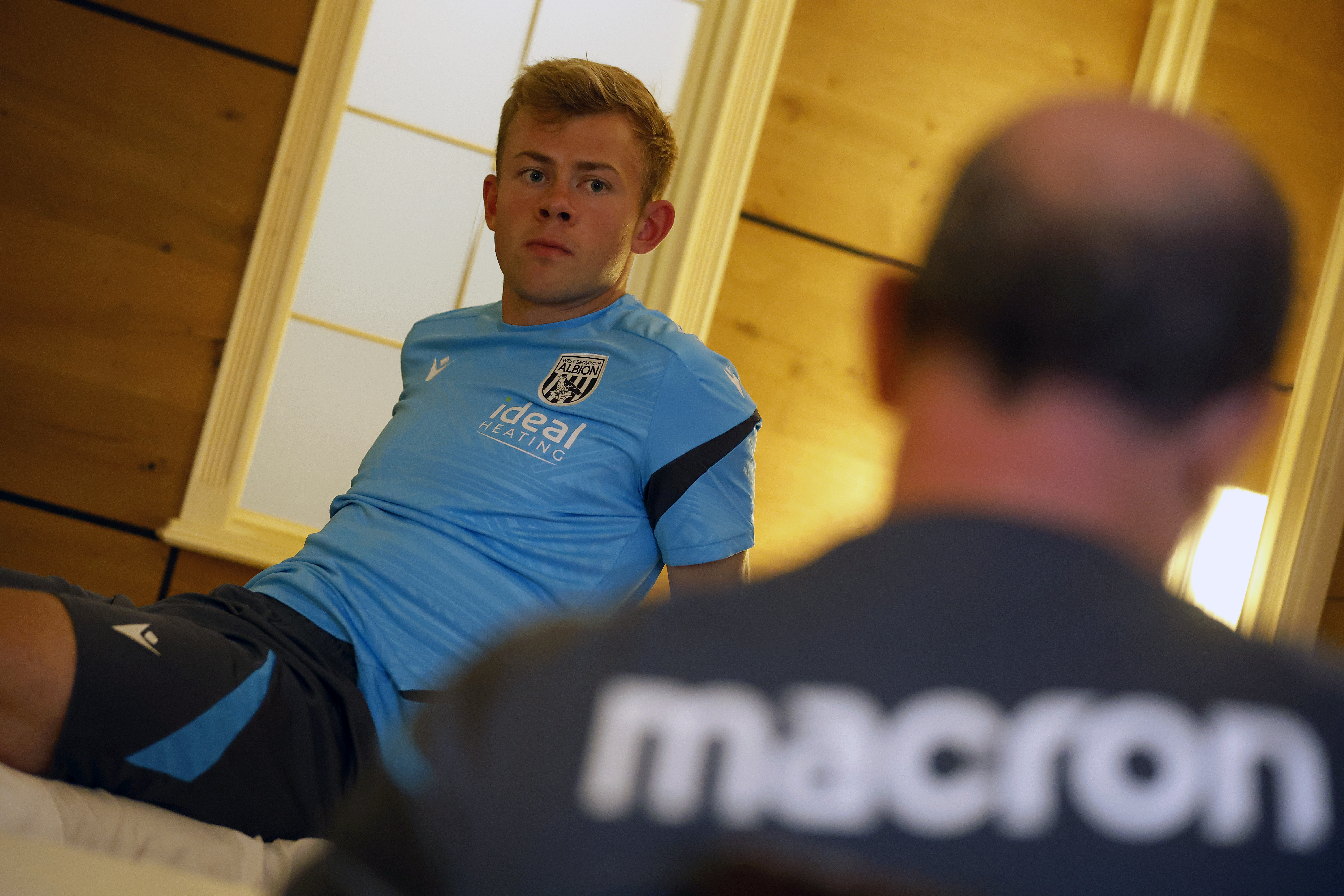 Aune Heggebø talking to a member of staff while sat on a medical bed