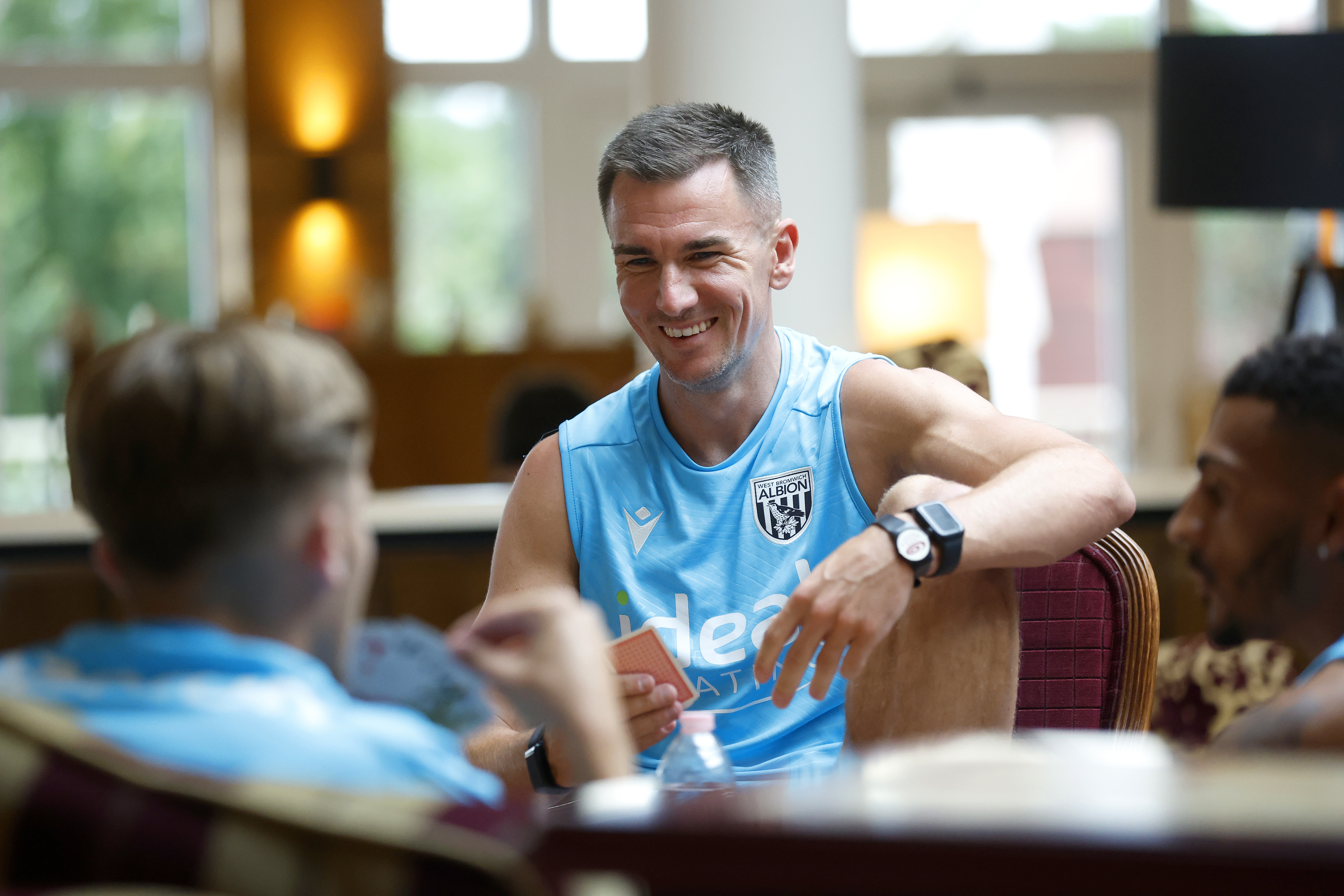 Jed Wallace smiling while playing cards