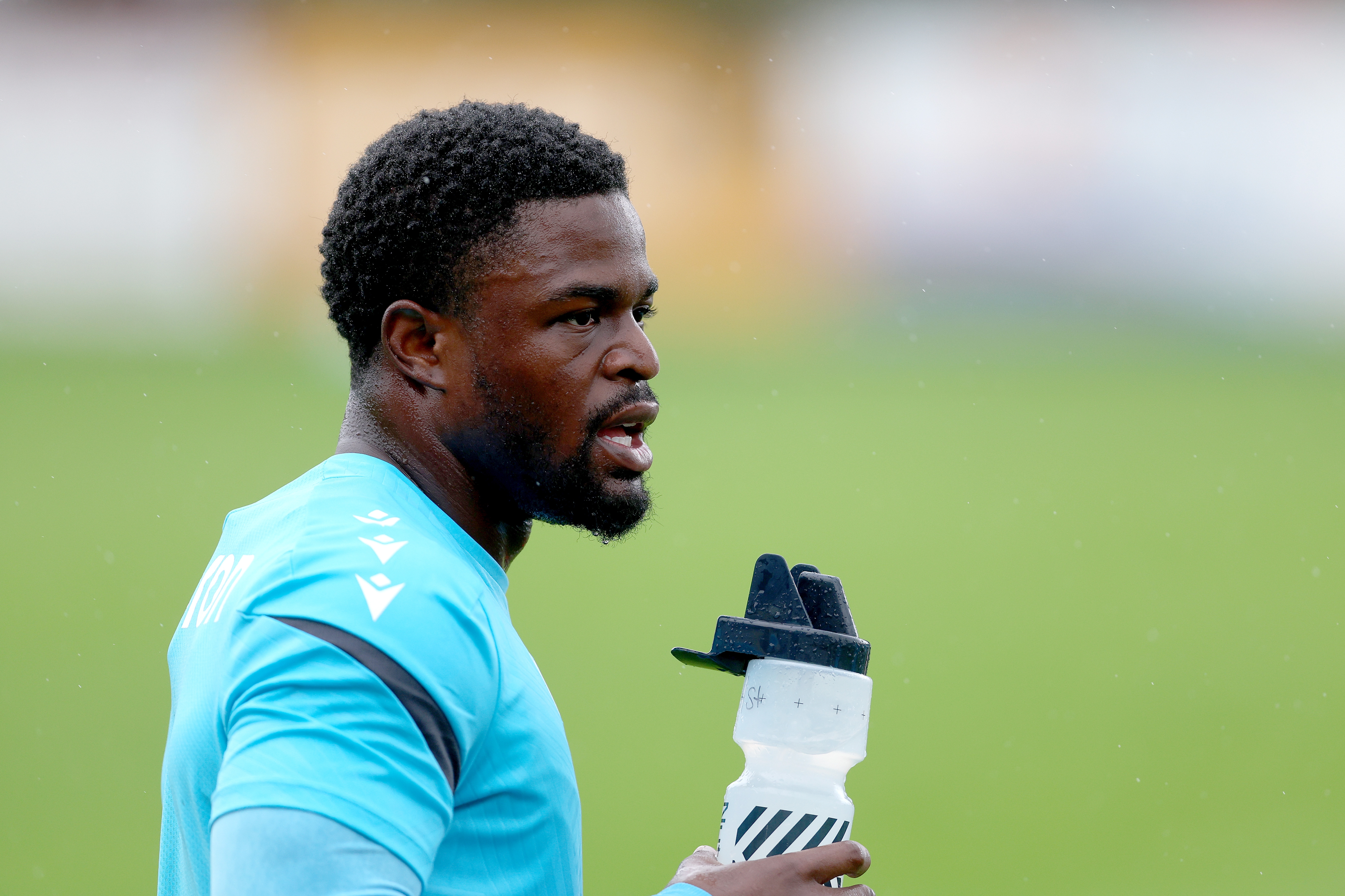 Josh Maja with a drink in his hand during a training session in the rain