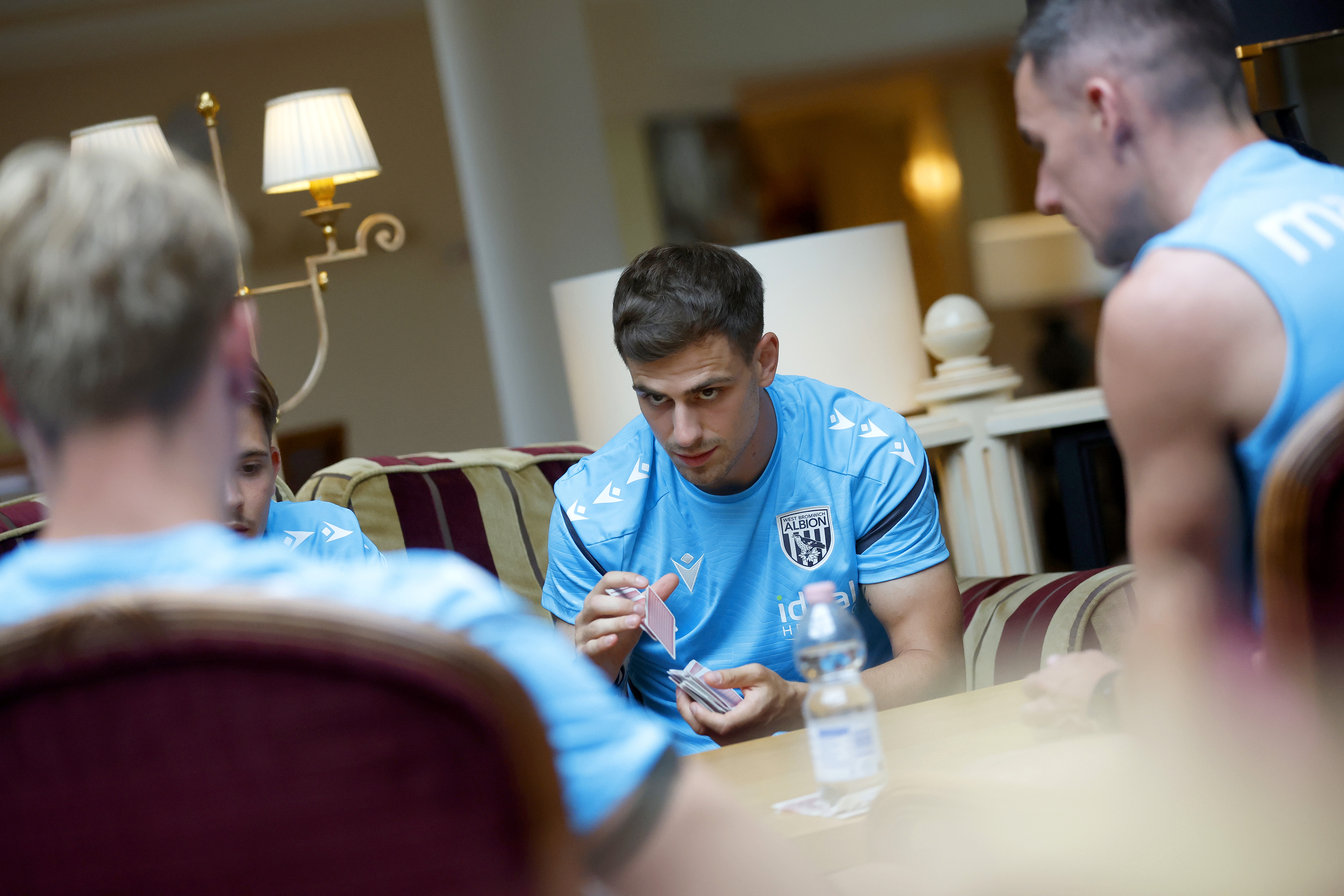 Jayson Molumby looking at his team-mates while playing cards