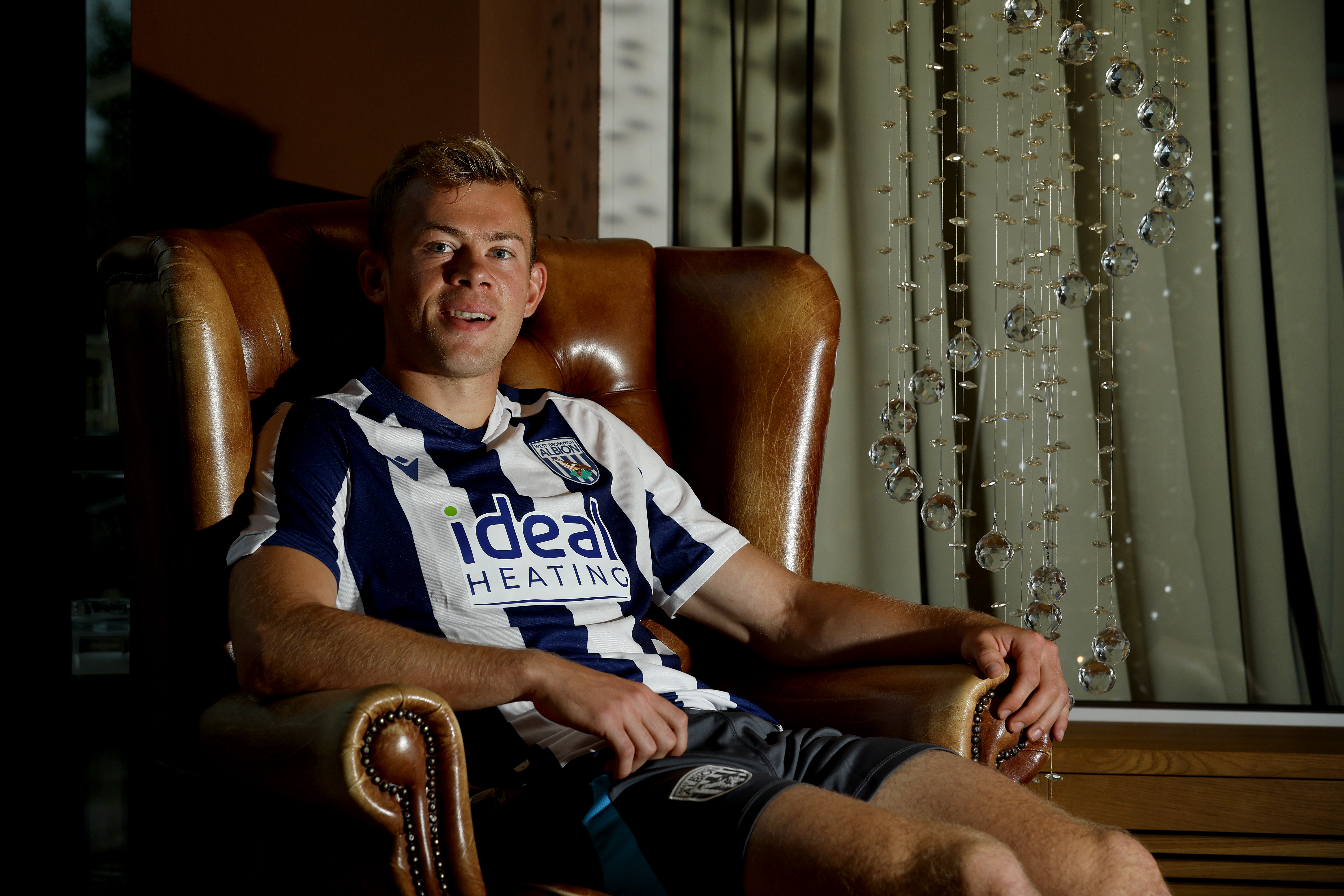 Aune Heggebø smiling at the camera while sat in a WBA shirt in a chair