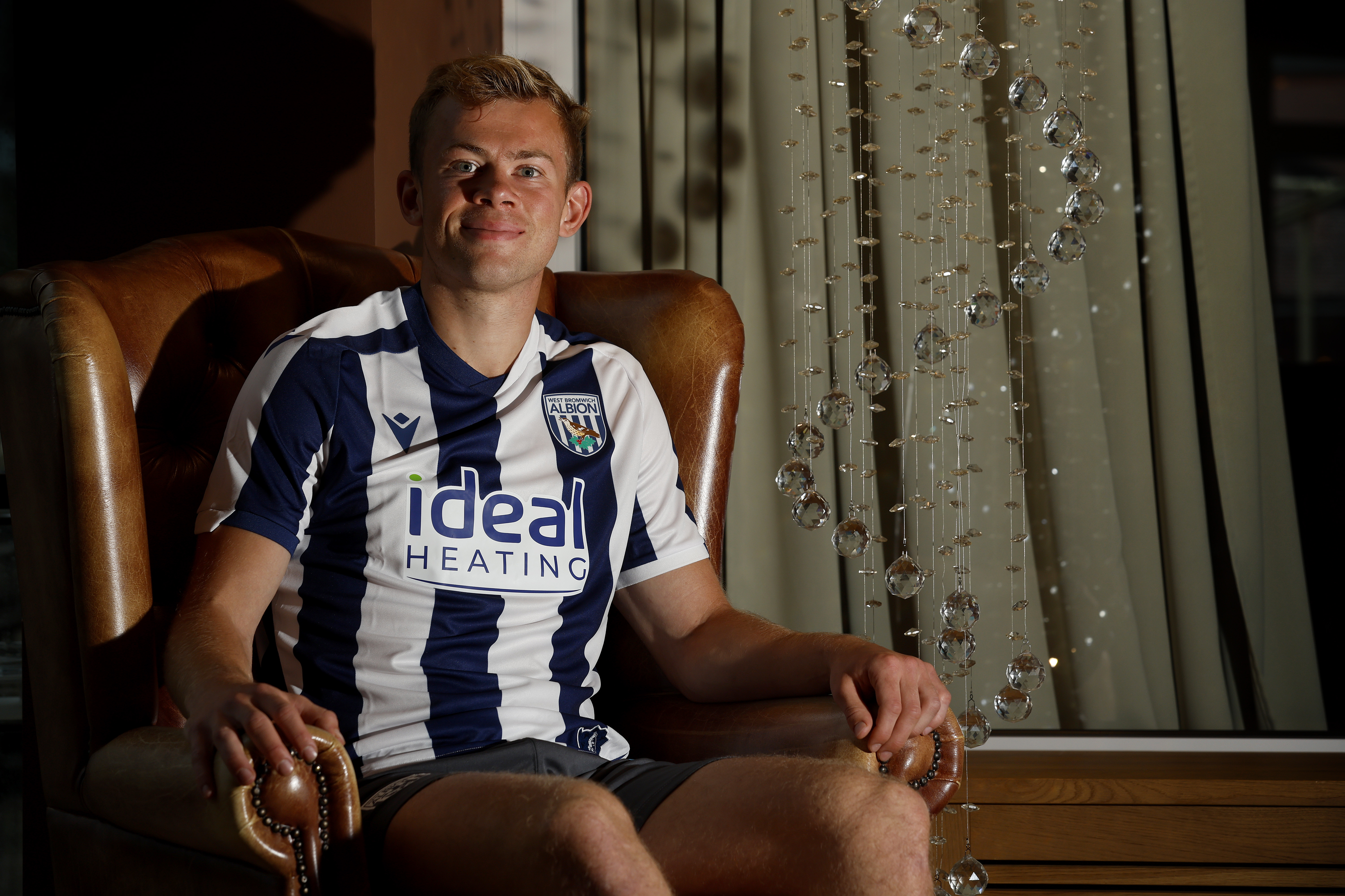 Aune Heggebø smiling at the camera while sat in a WBA shirt in a chair
