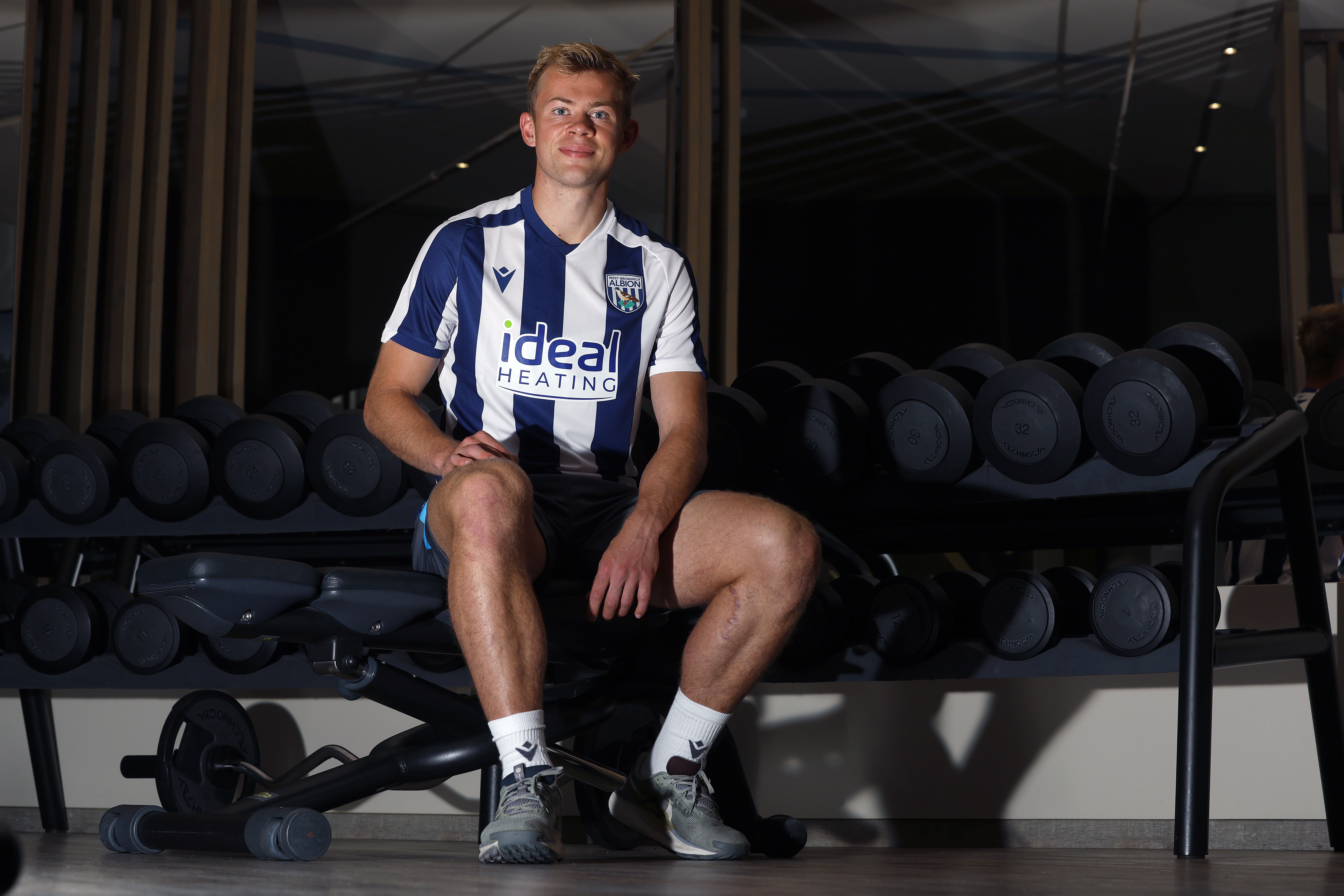 Aune Heggebø smiling at the camera while sat in the gym in a WBA shirt 