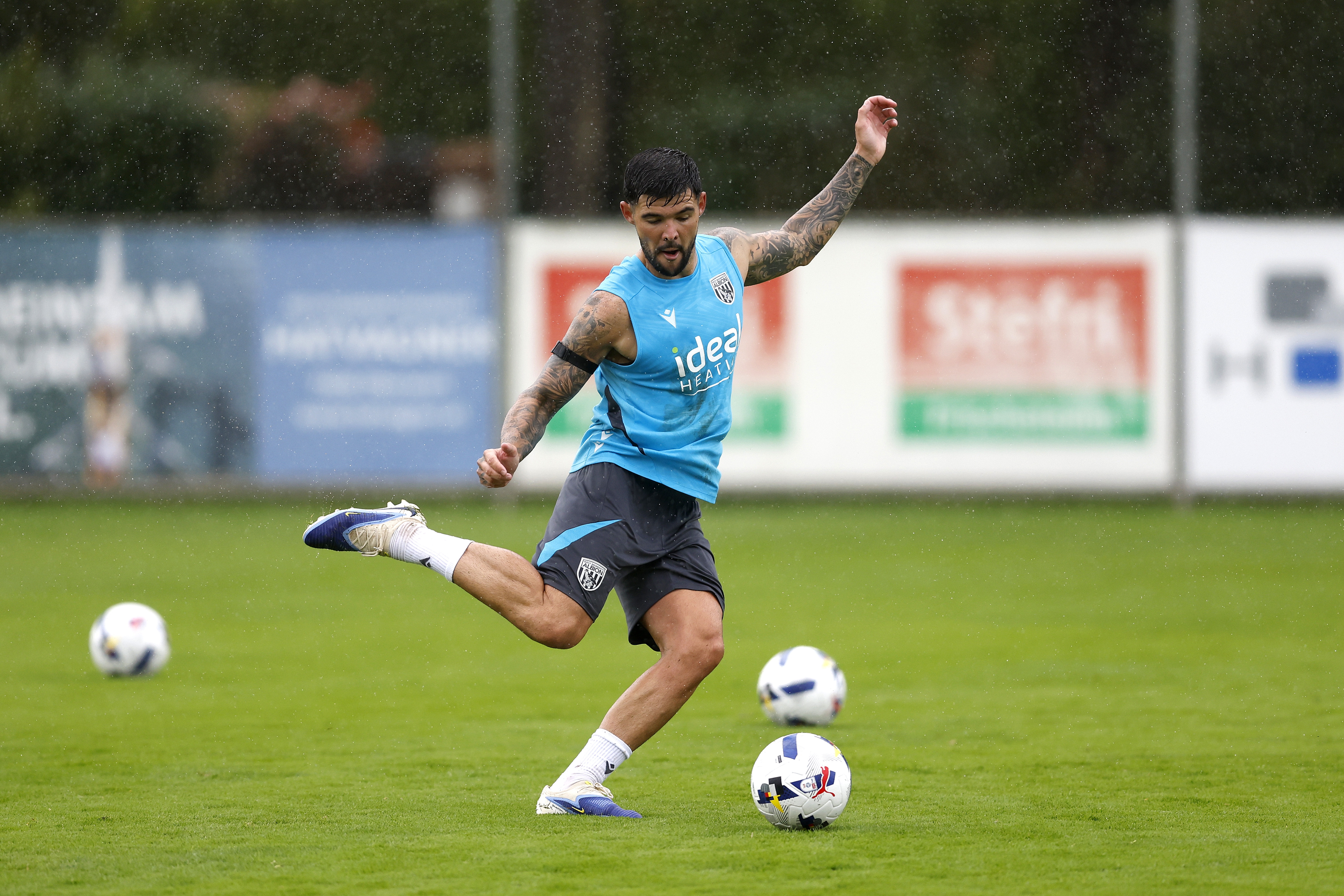 Alex Mowatt striking the ball during a training session in the rain