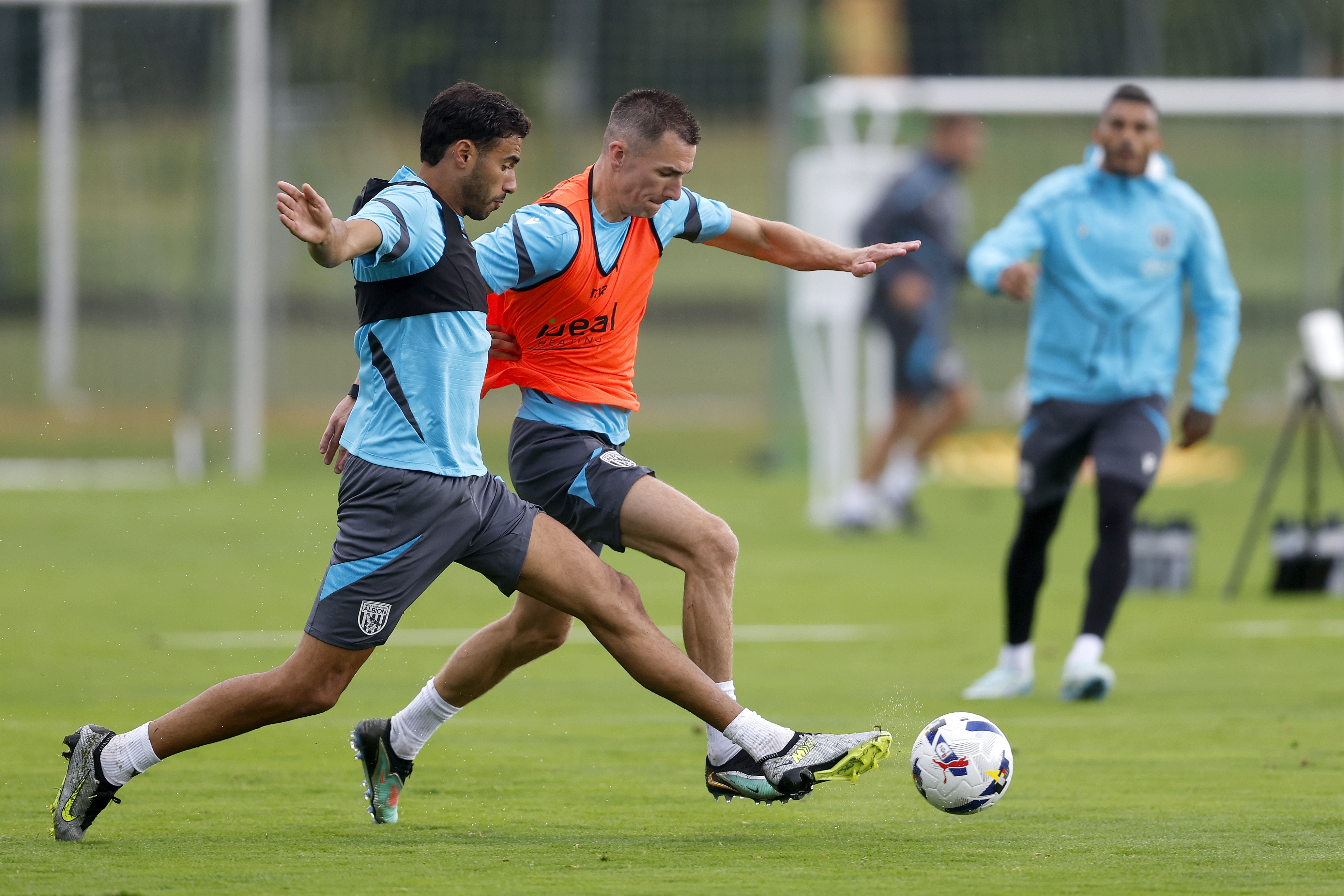 Gianluca Frabotta and Jed Wallace fighting for the ball during a training session in the rain