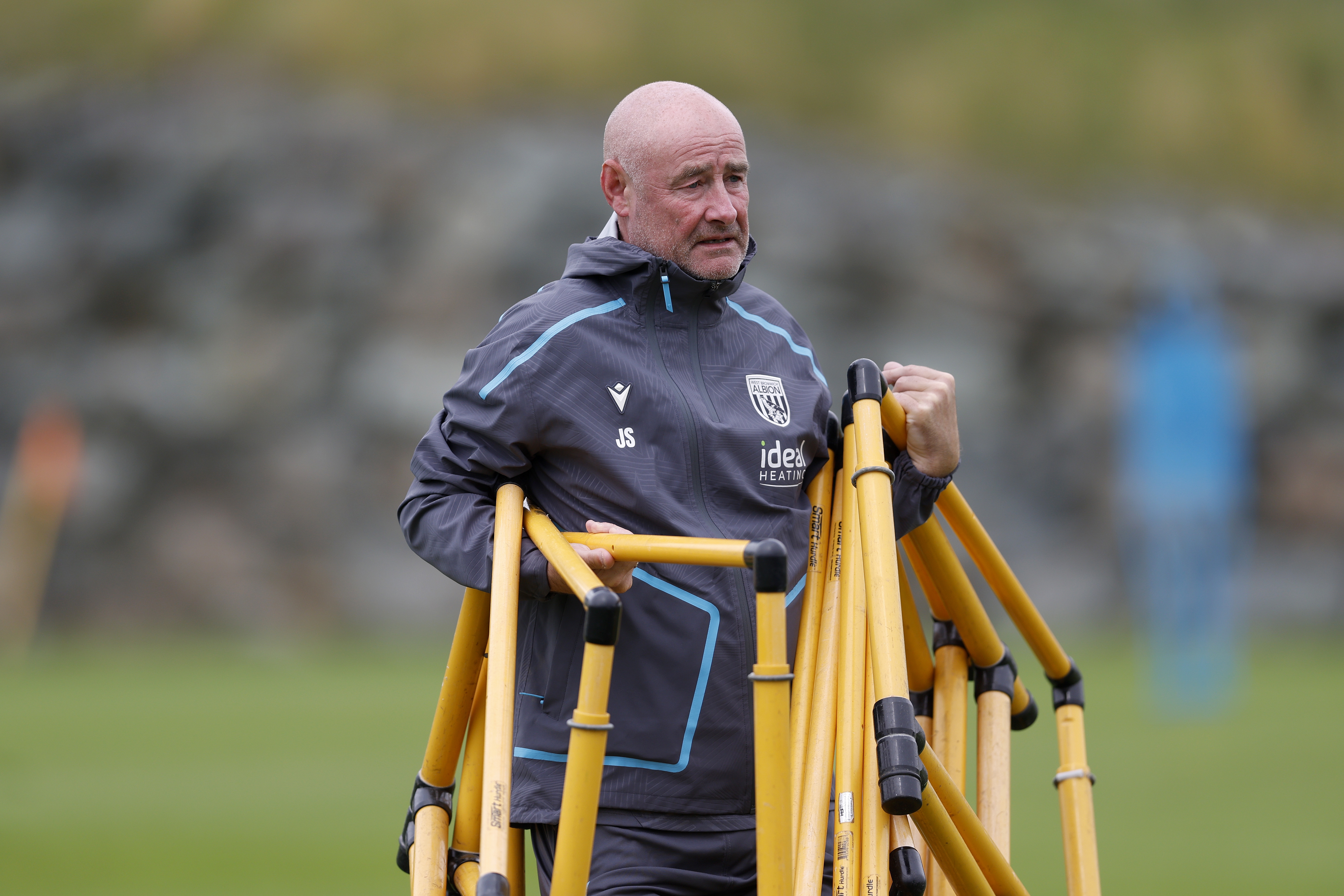 Albion staff member Jacko Smyth carrying equipment on the training pitch in Austria 