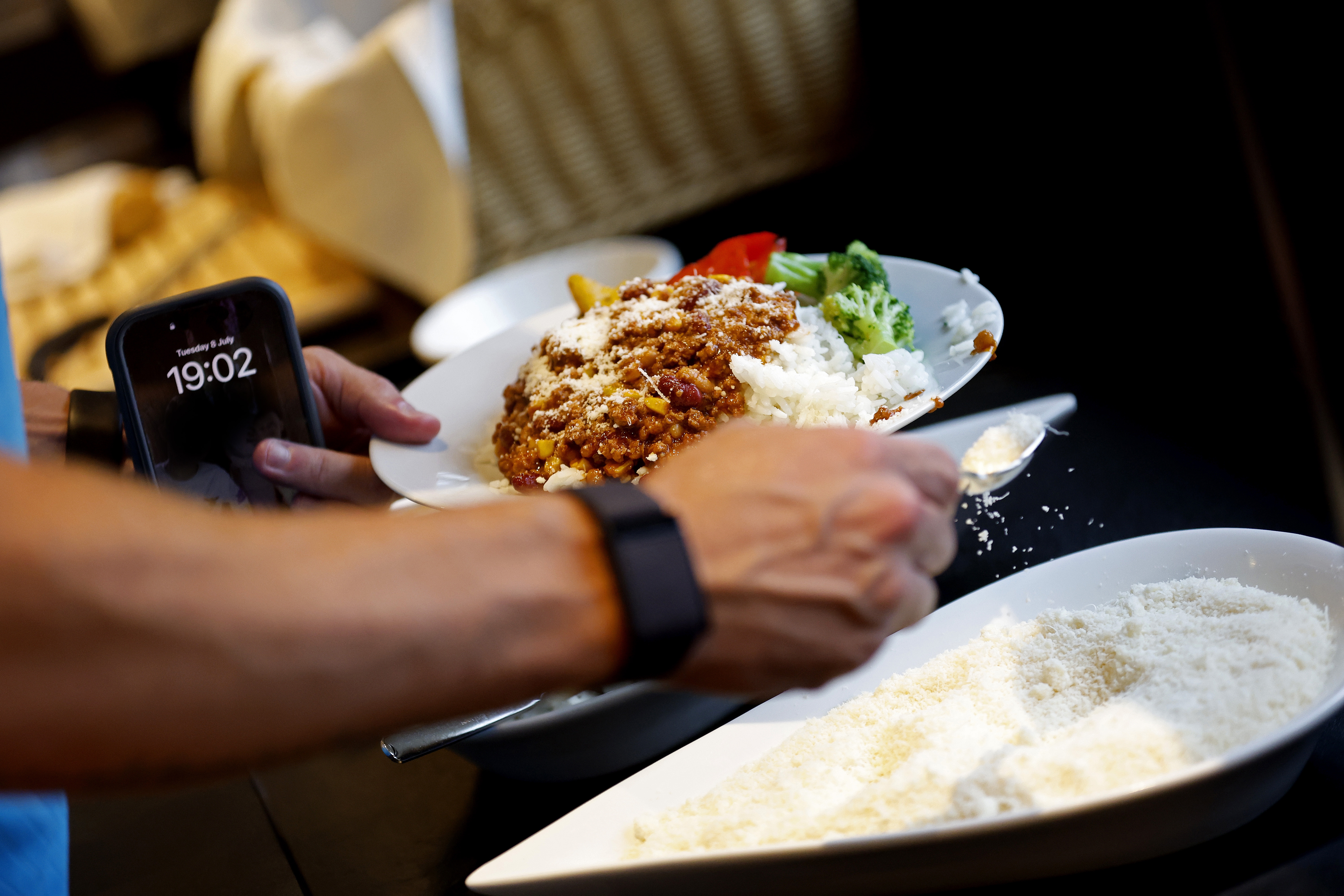 Dinner on a plate with mozzarella cheese being poured on