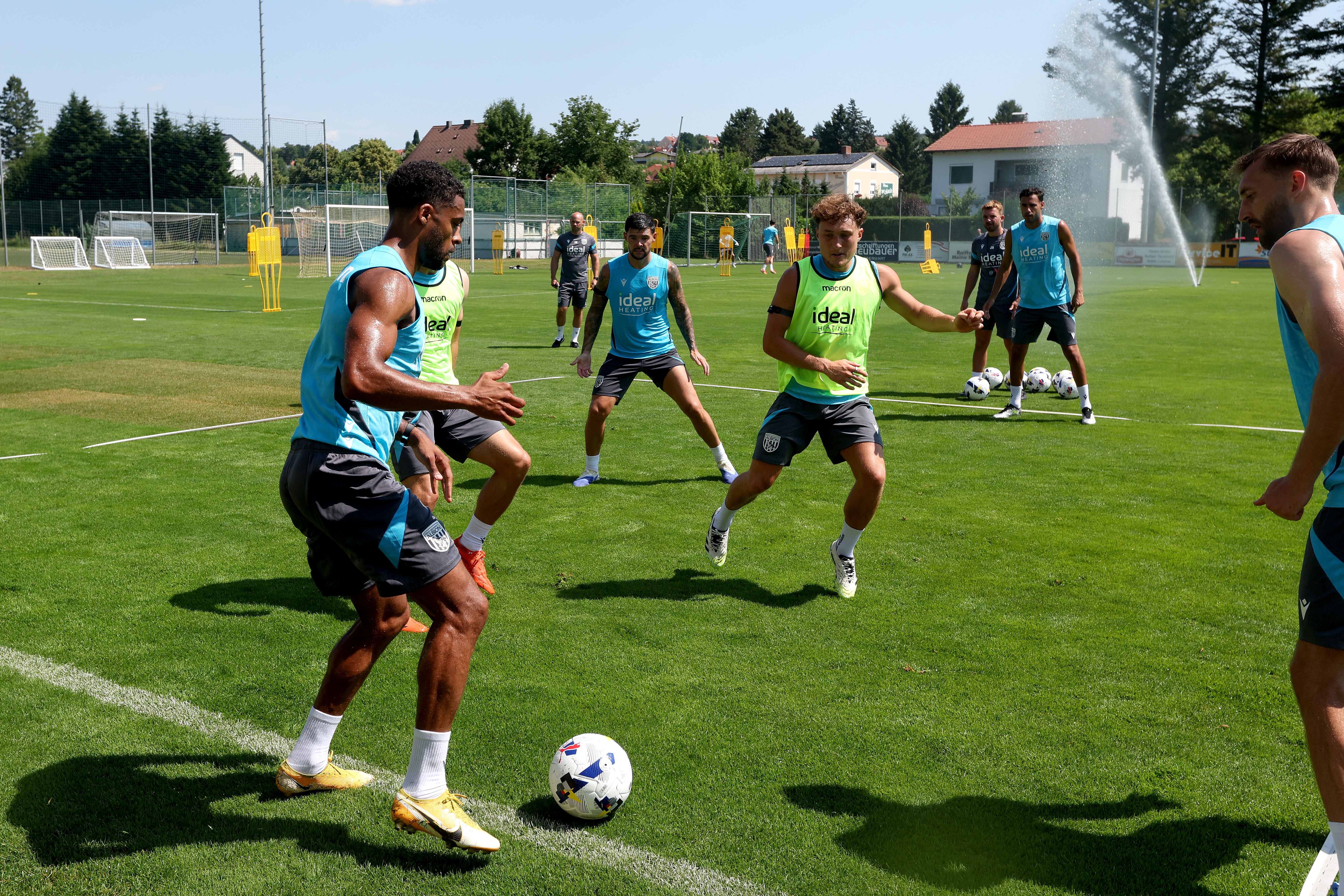 Darnell Furlong on the ball during a training session with several players around him