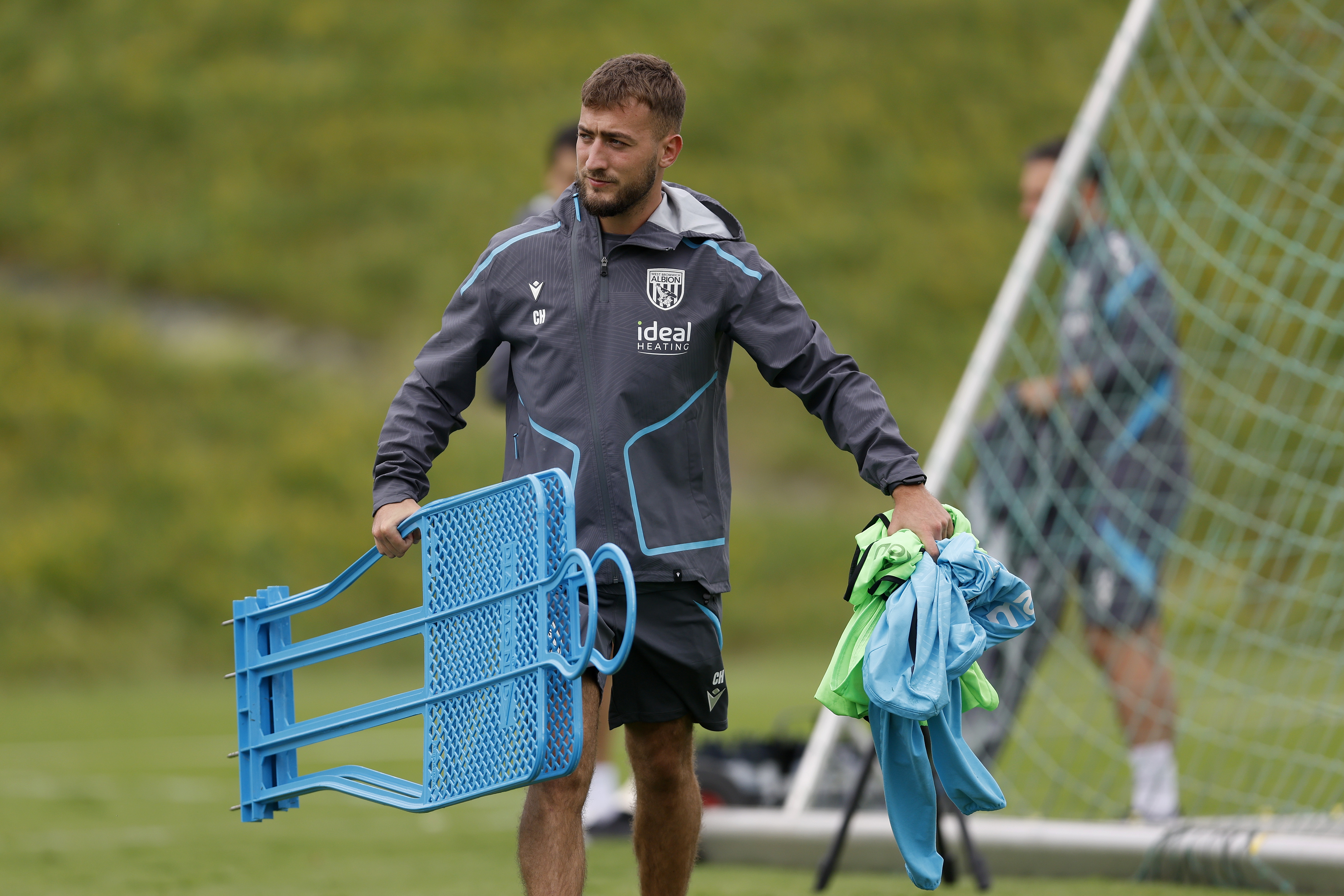 Albion kit man Curtis Holmes carrying equipment on the training pitch