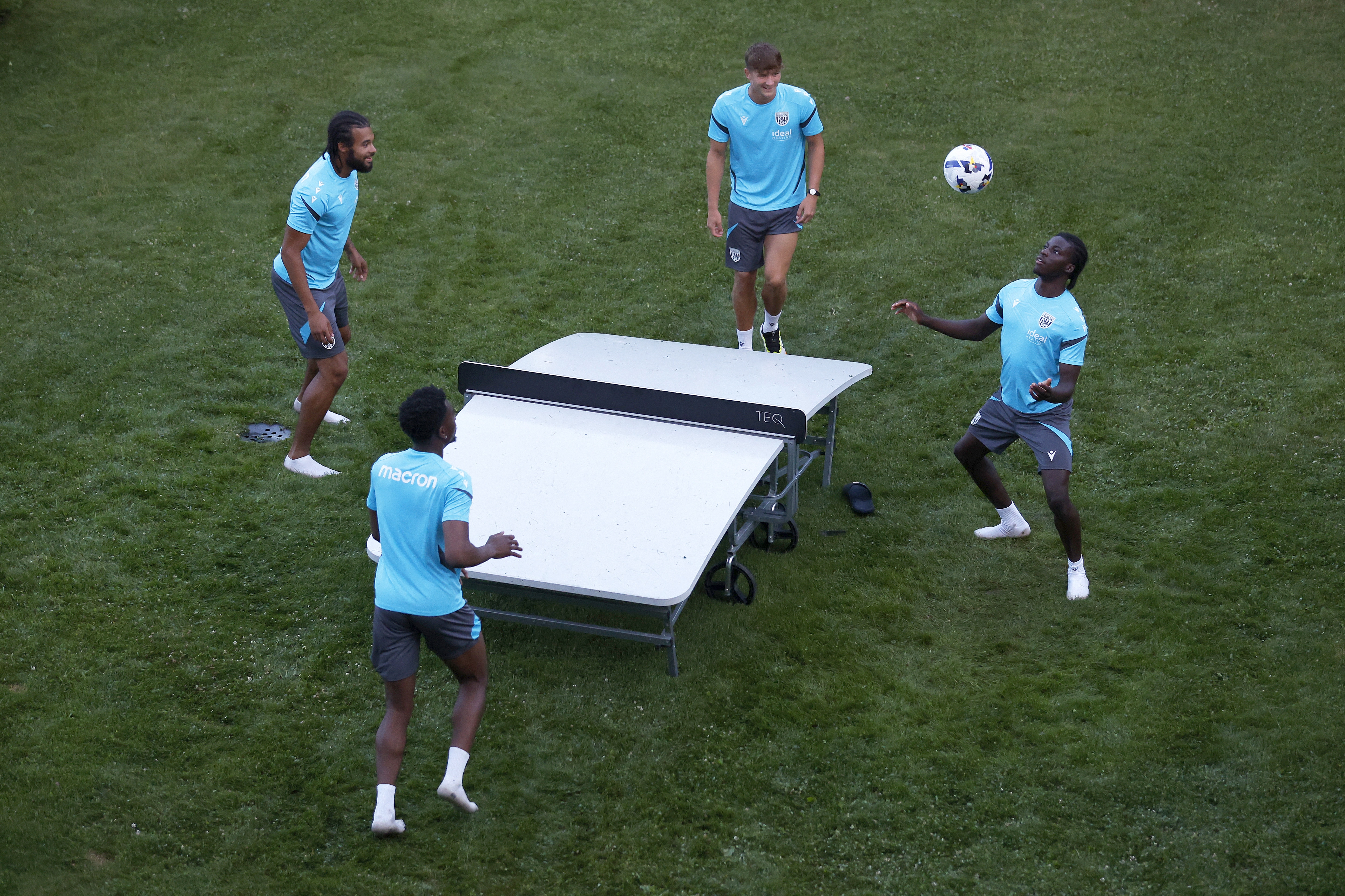 Four young players playing football tennis 
