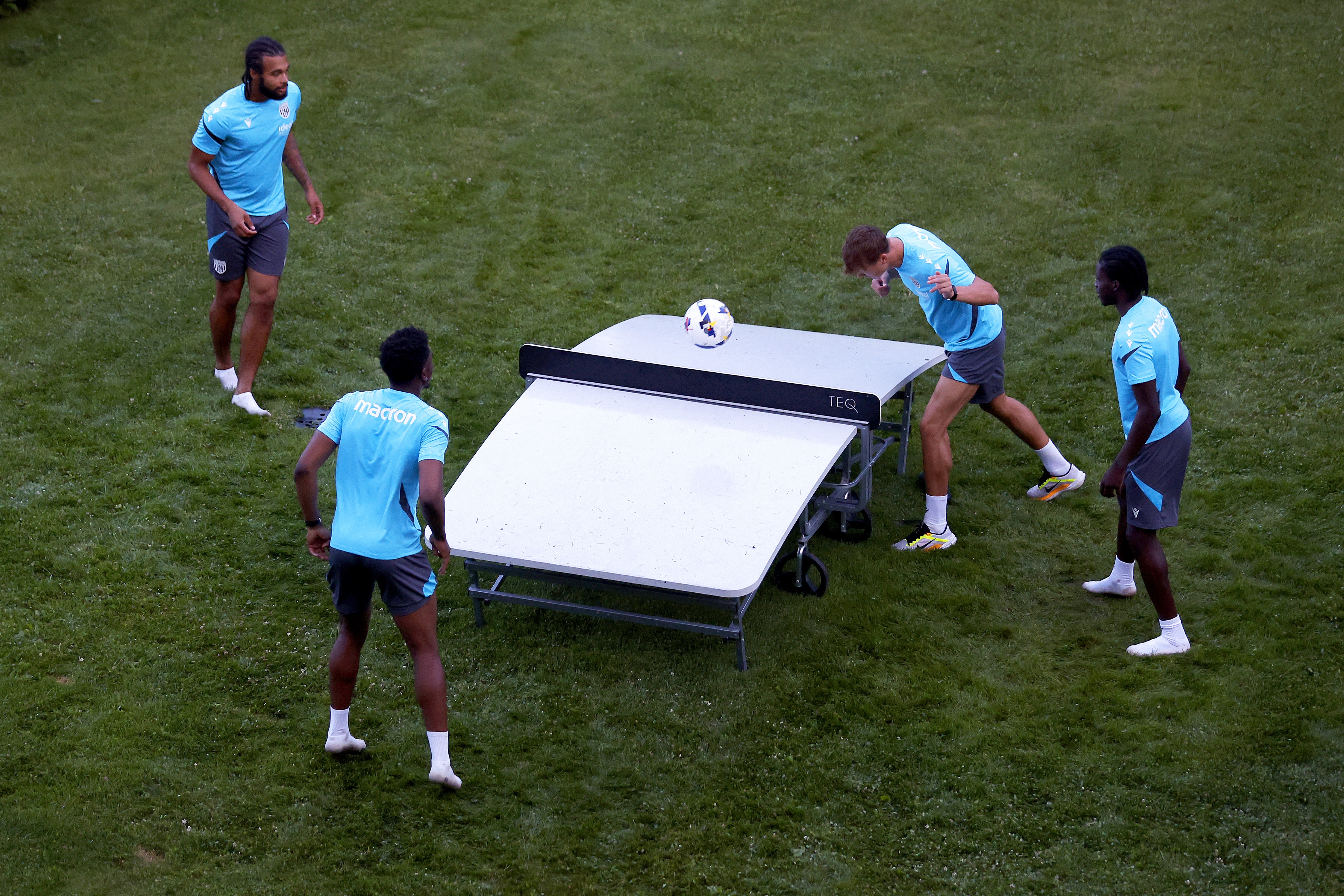 Four young players playing football tennis 