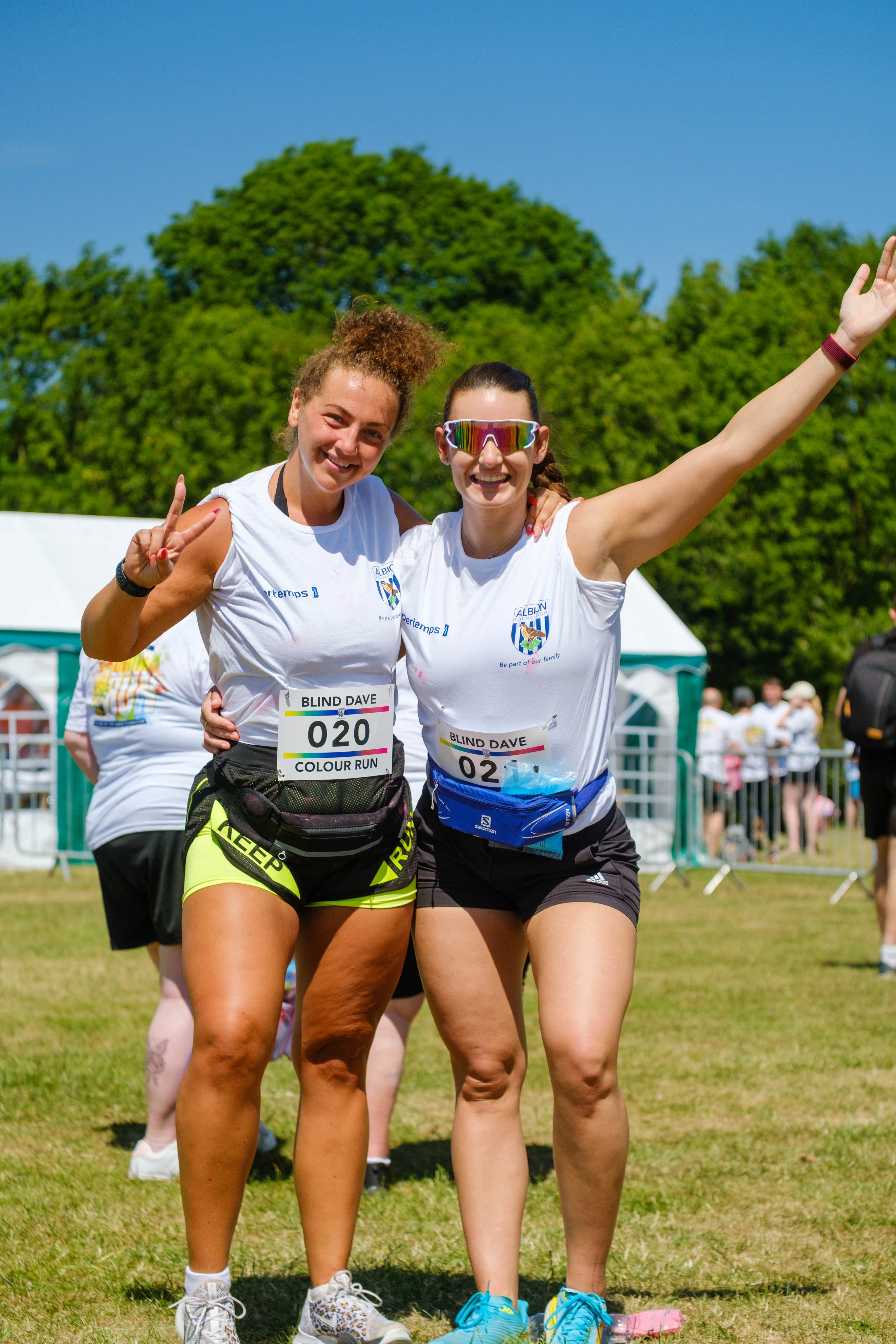 Two participants smiling, one showing a peace sign and the other with arm raised.