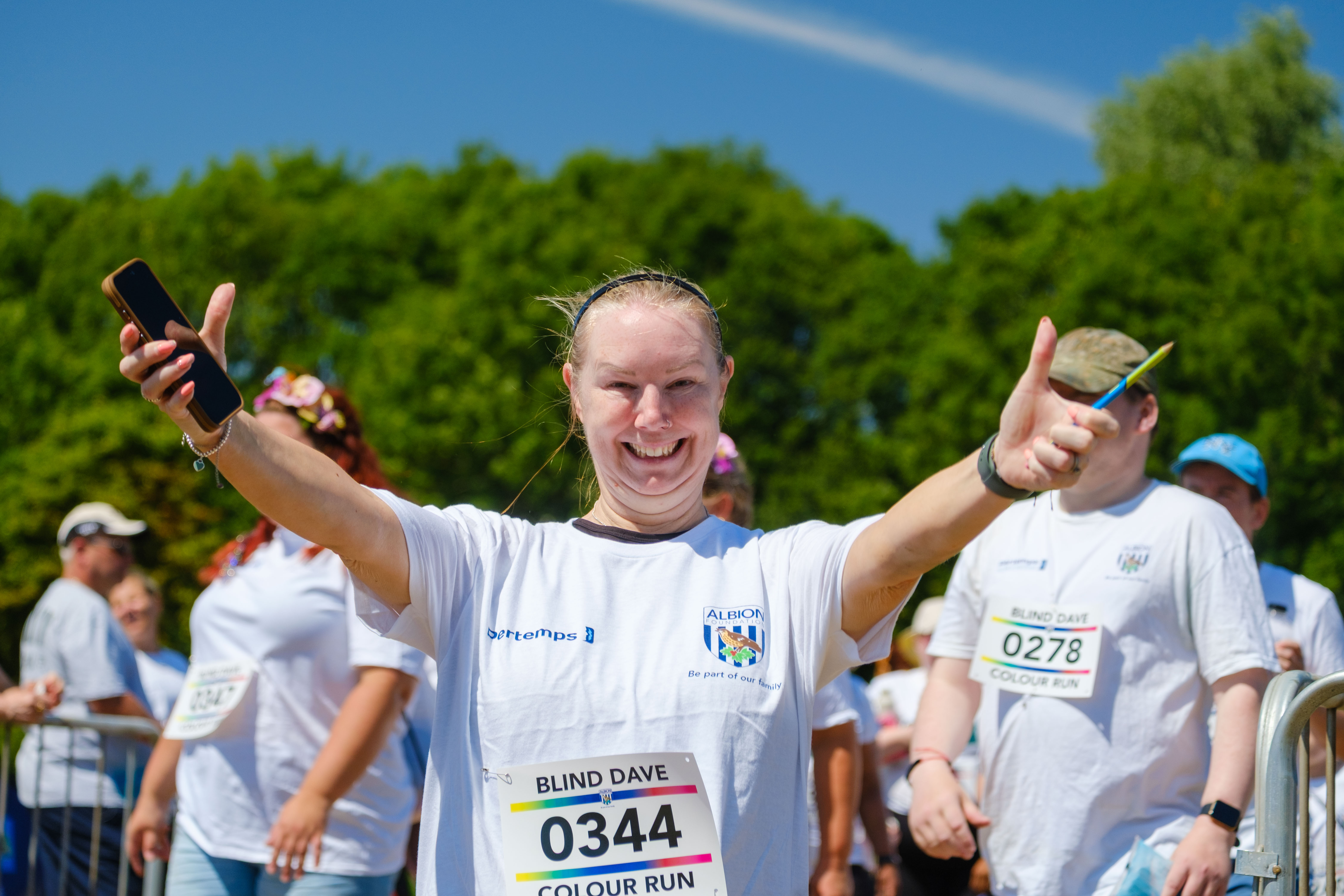 A runners walking in to the warm up area, with arms out in joy.