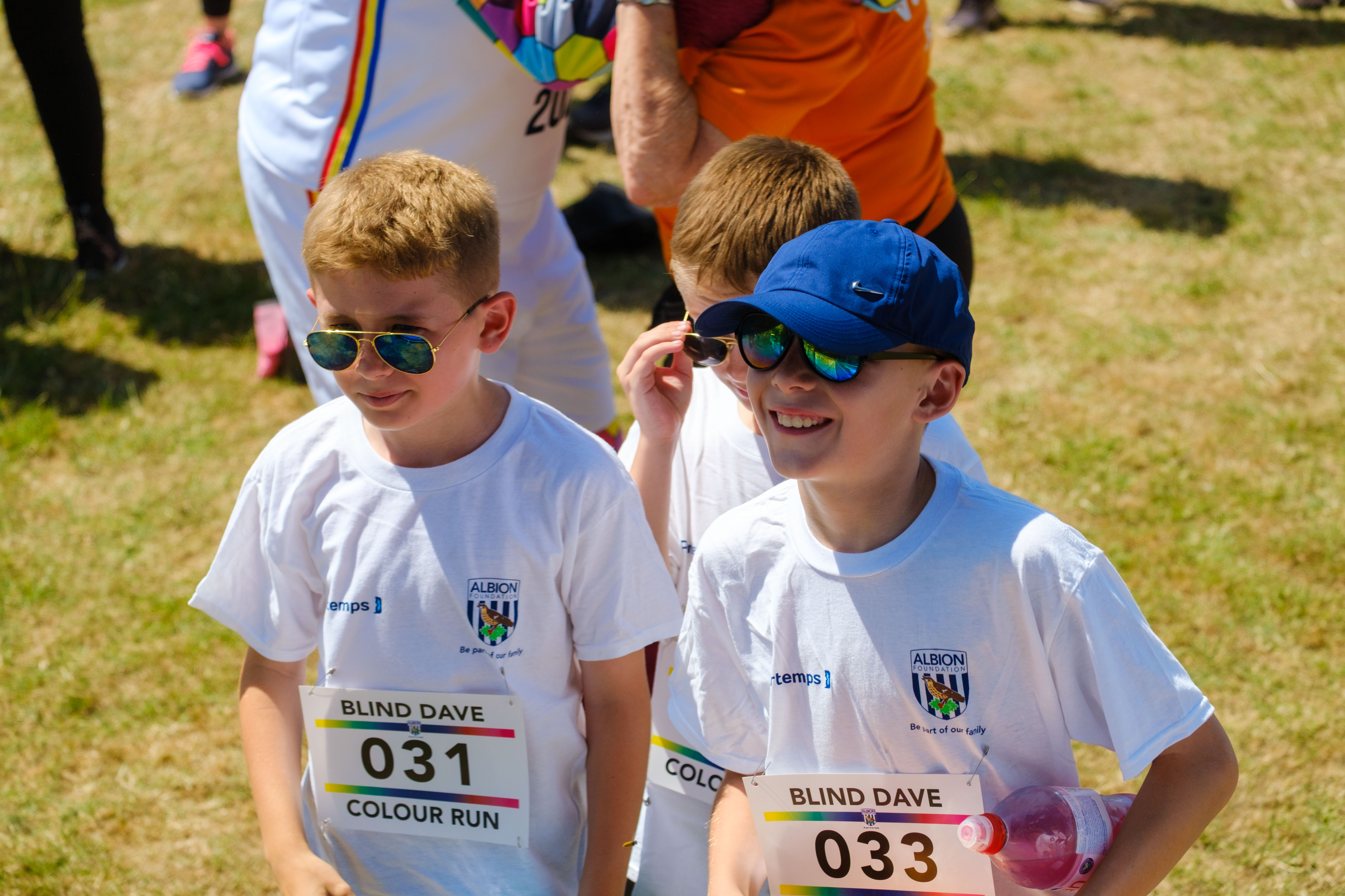 Young participants smiling, wearing sunglasses.