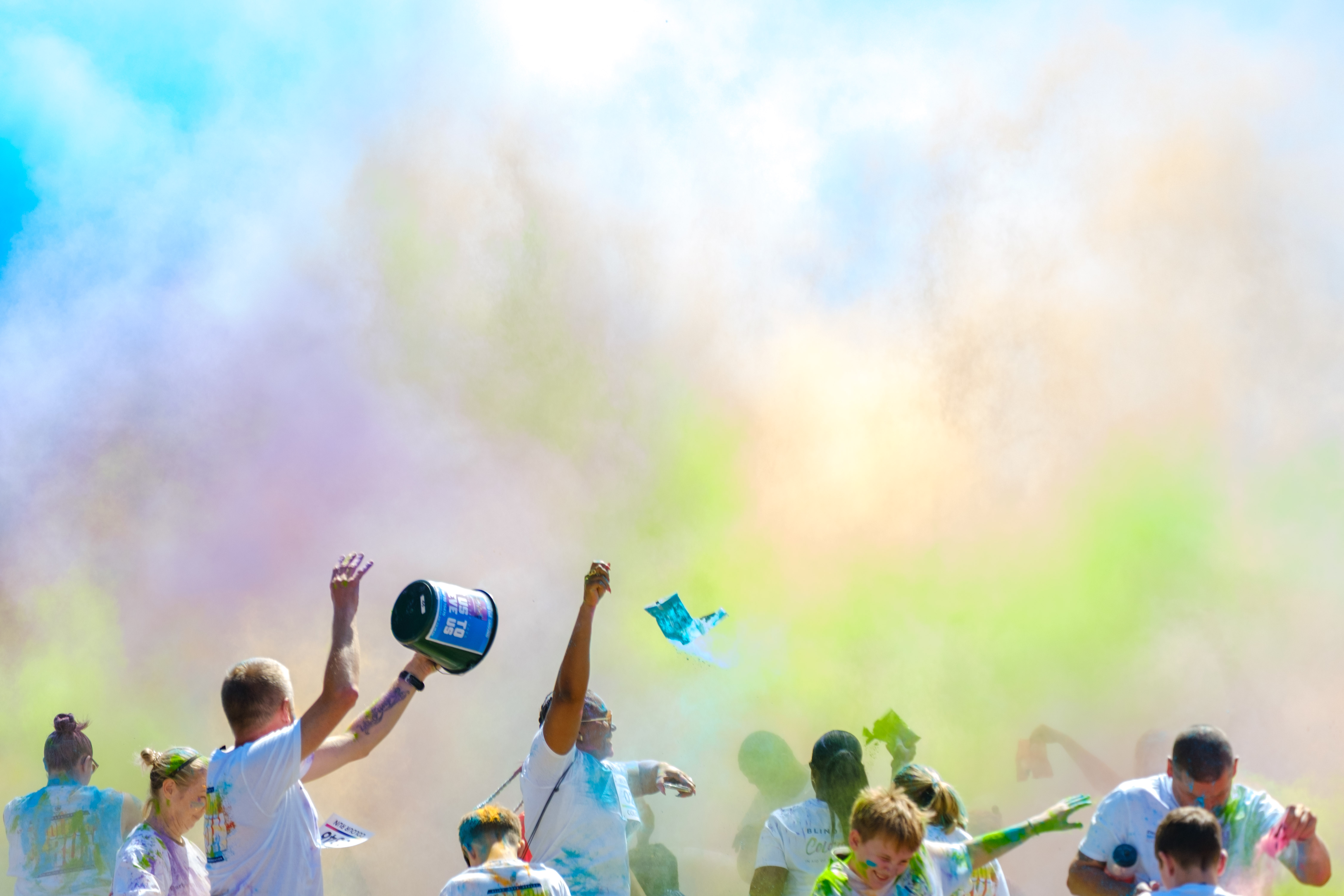 Cloud of colour after the paint throw, participants cover in paint.