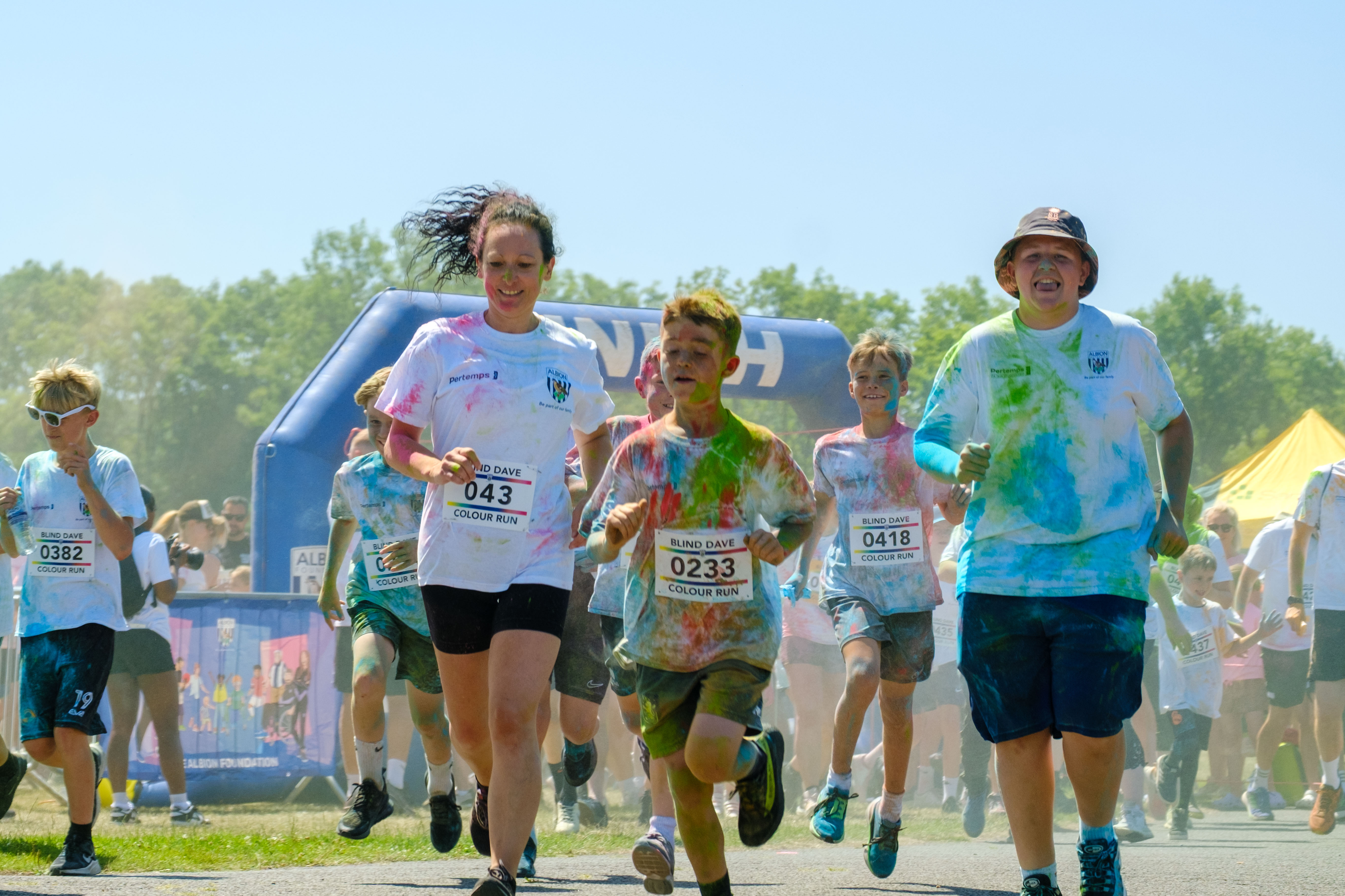 Runners covered in paint, leaving the start line.