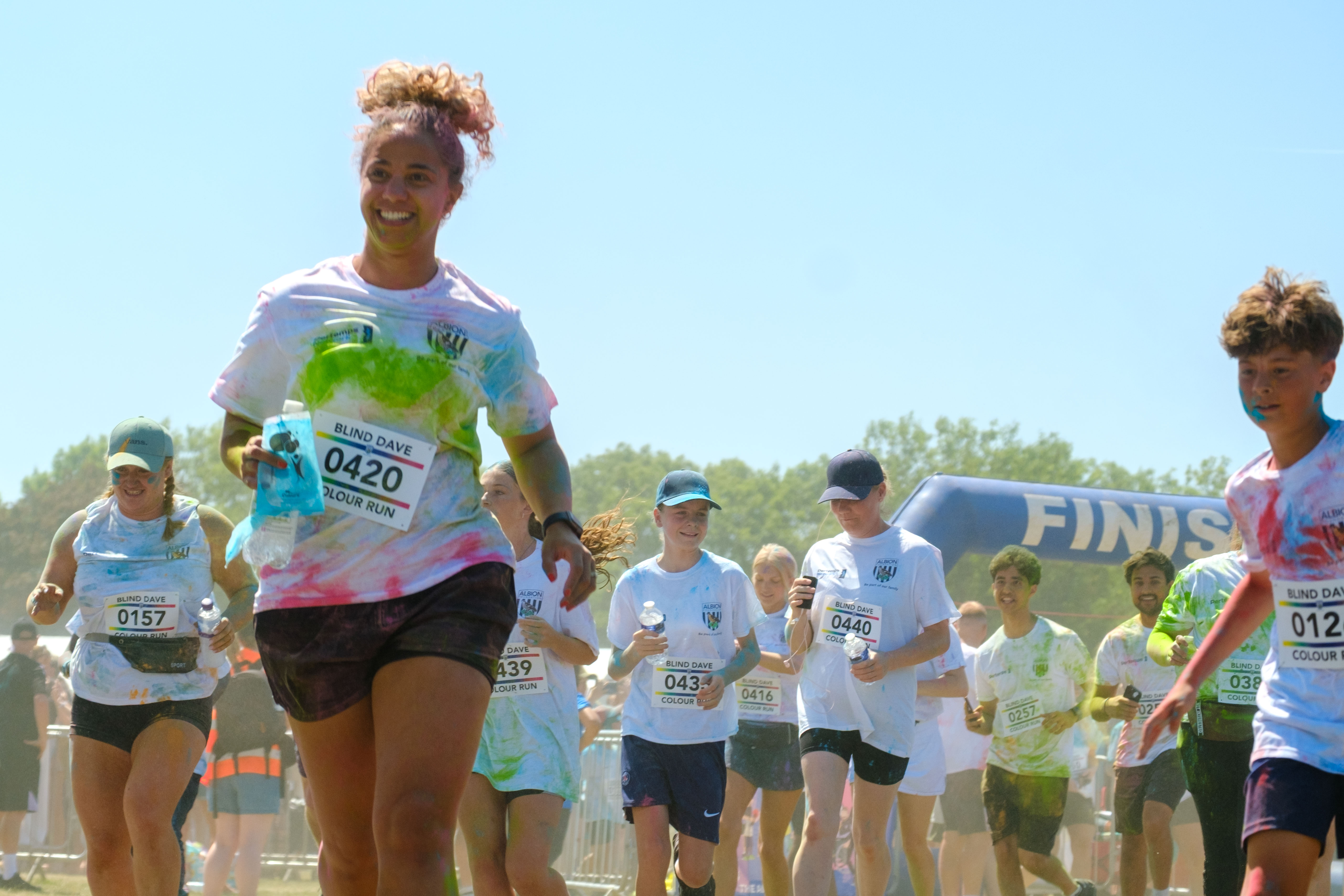 Runners covered in paint, leaving the start line.