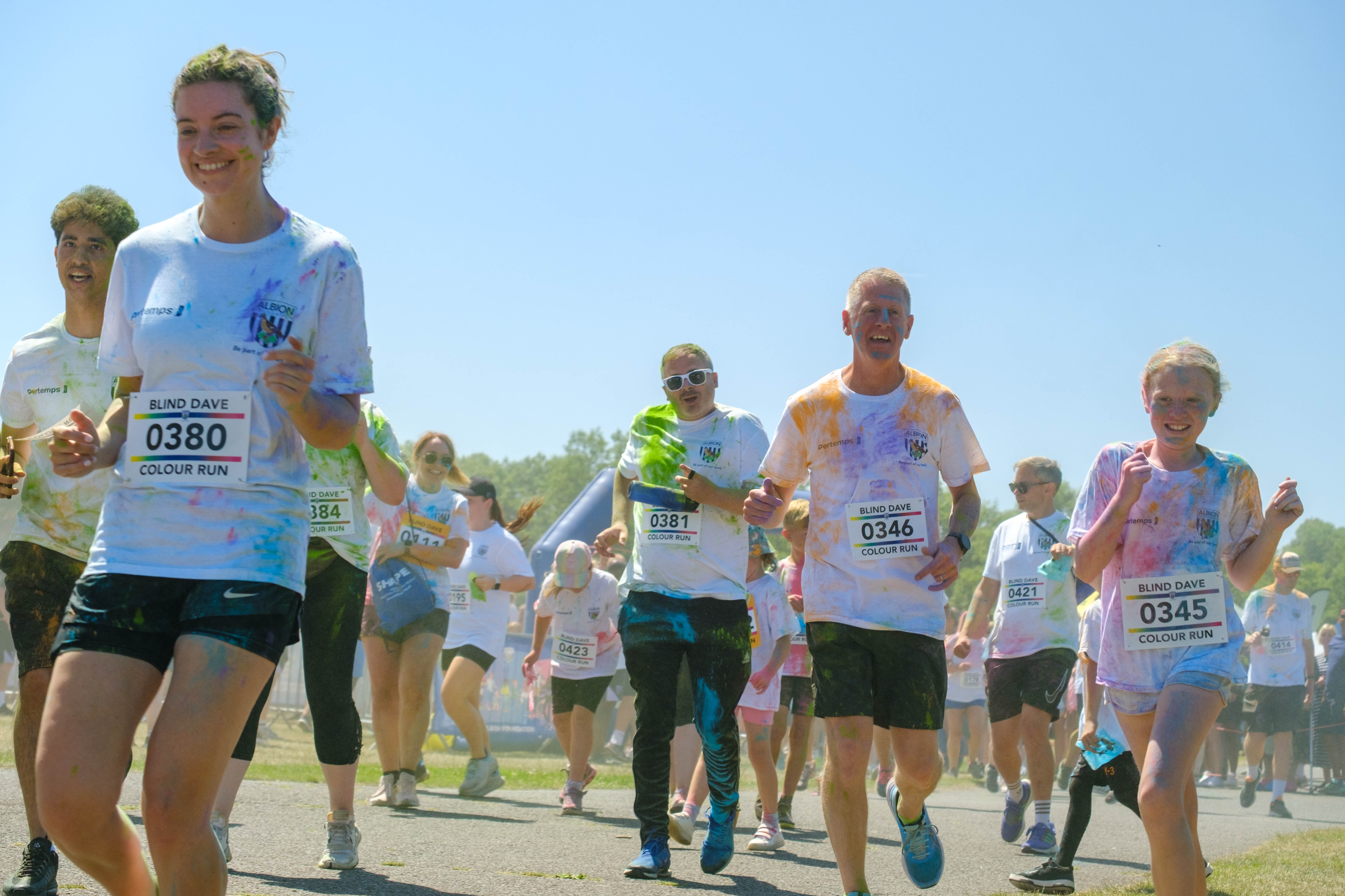 Runners covered in paint, leaving the start line.