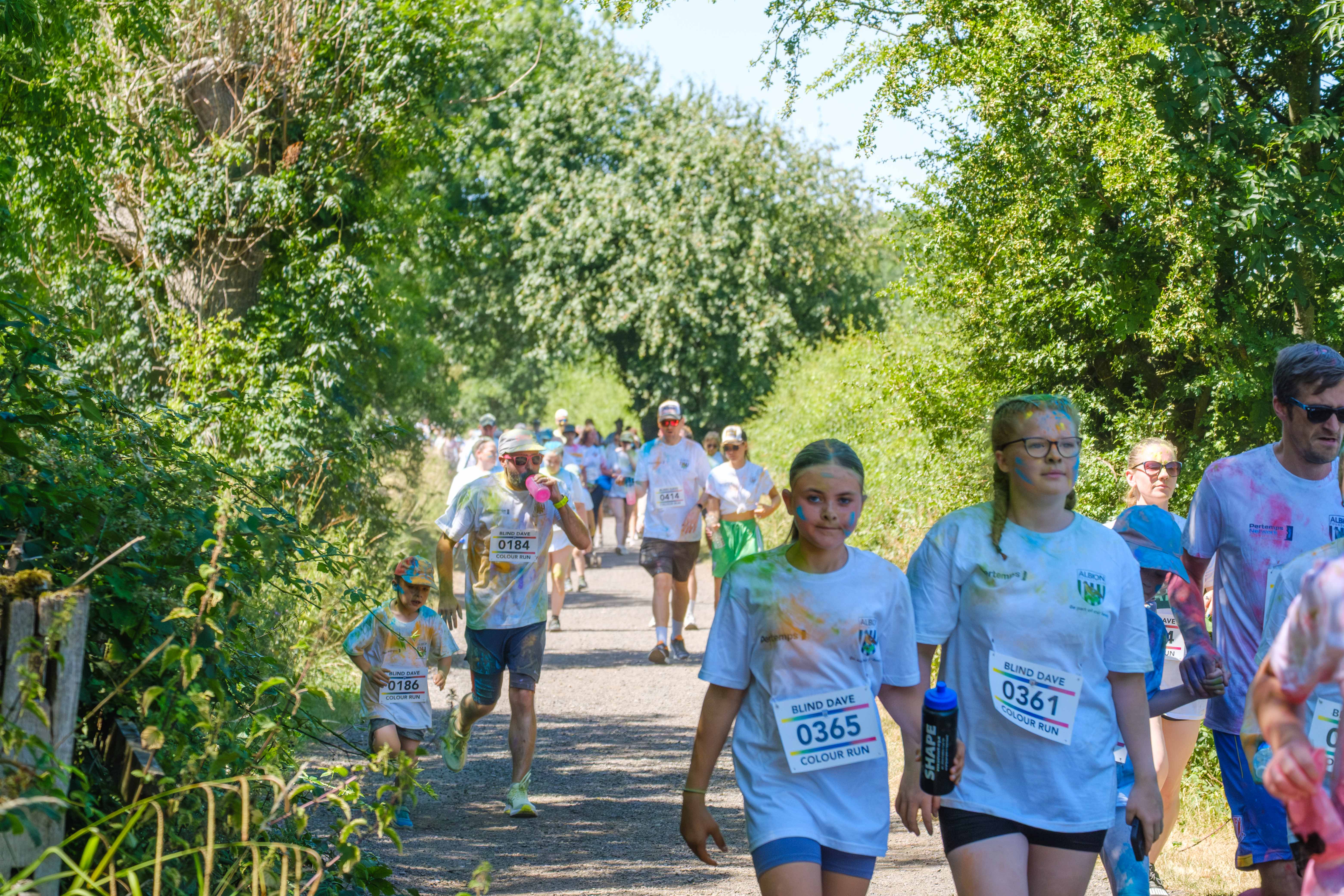 Participants walking through shaded greenery.