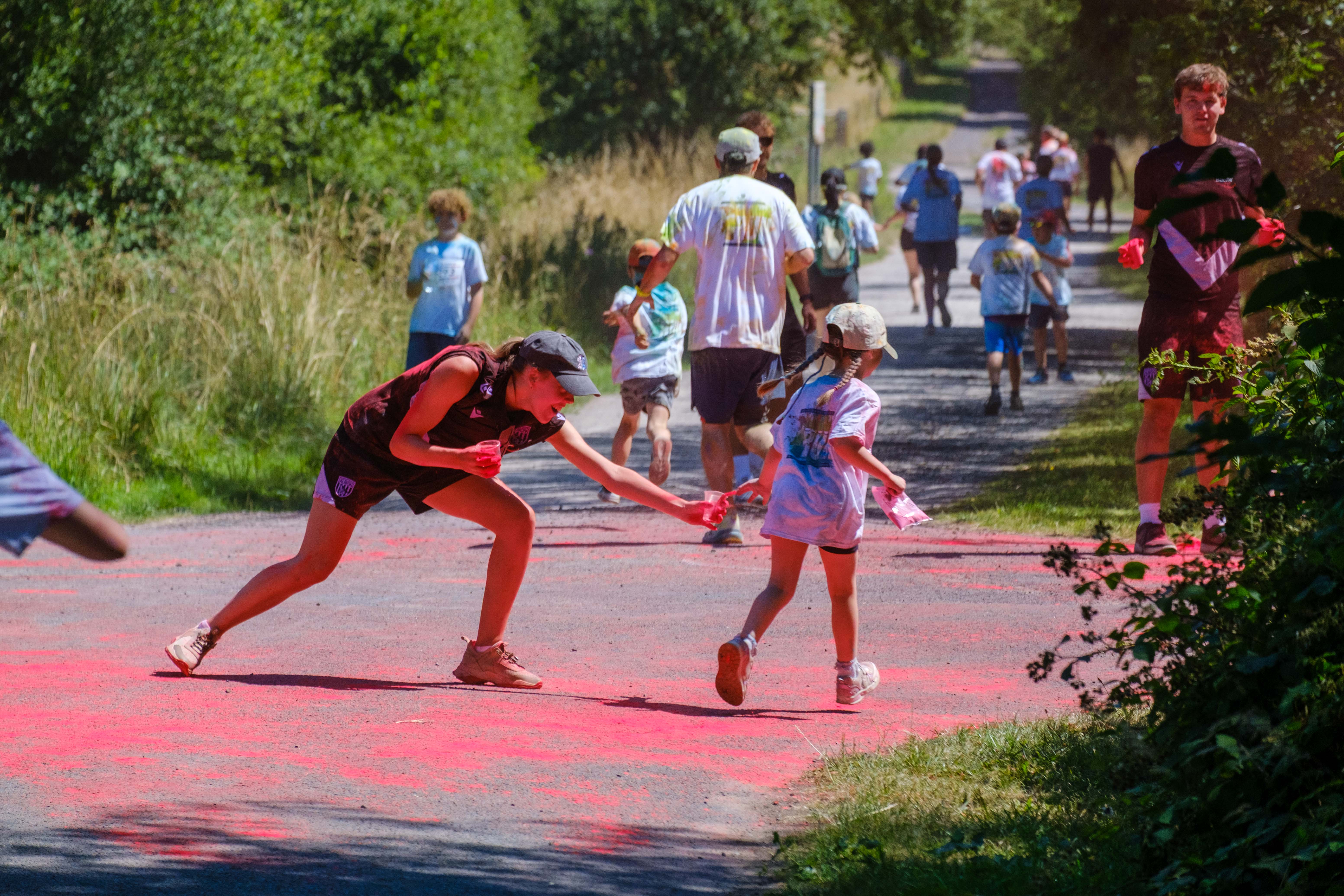 Foundation staff aiming paint powder at a passing runner.