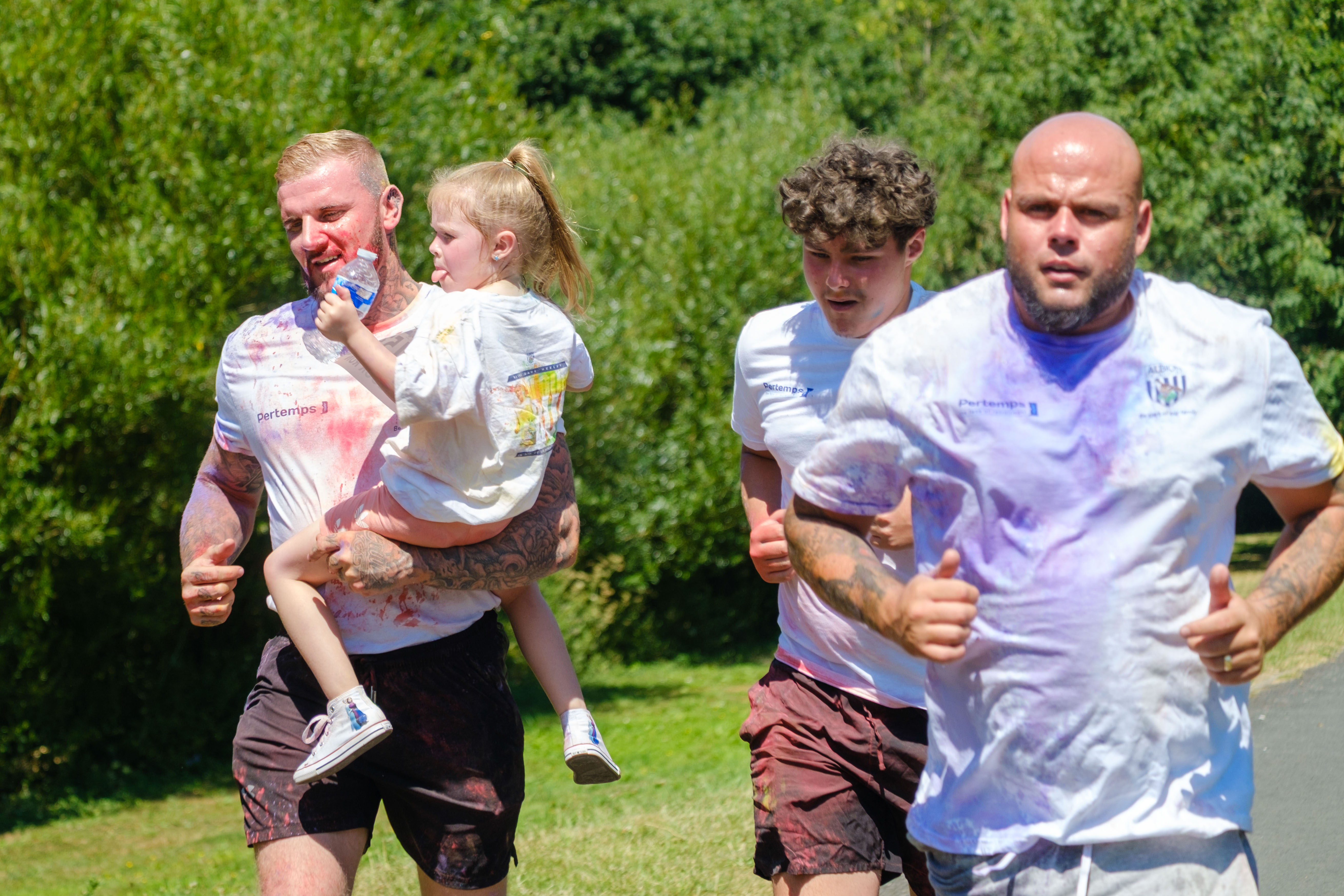 Three adult men, with one carrying a child.