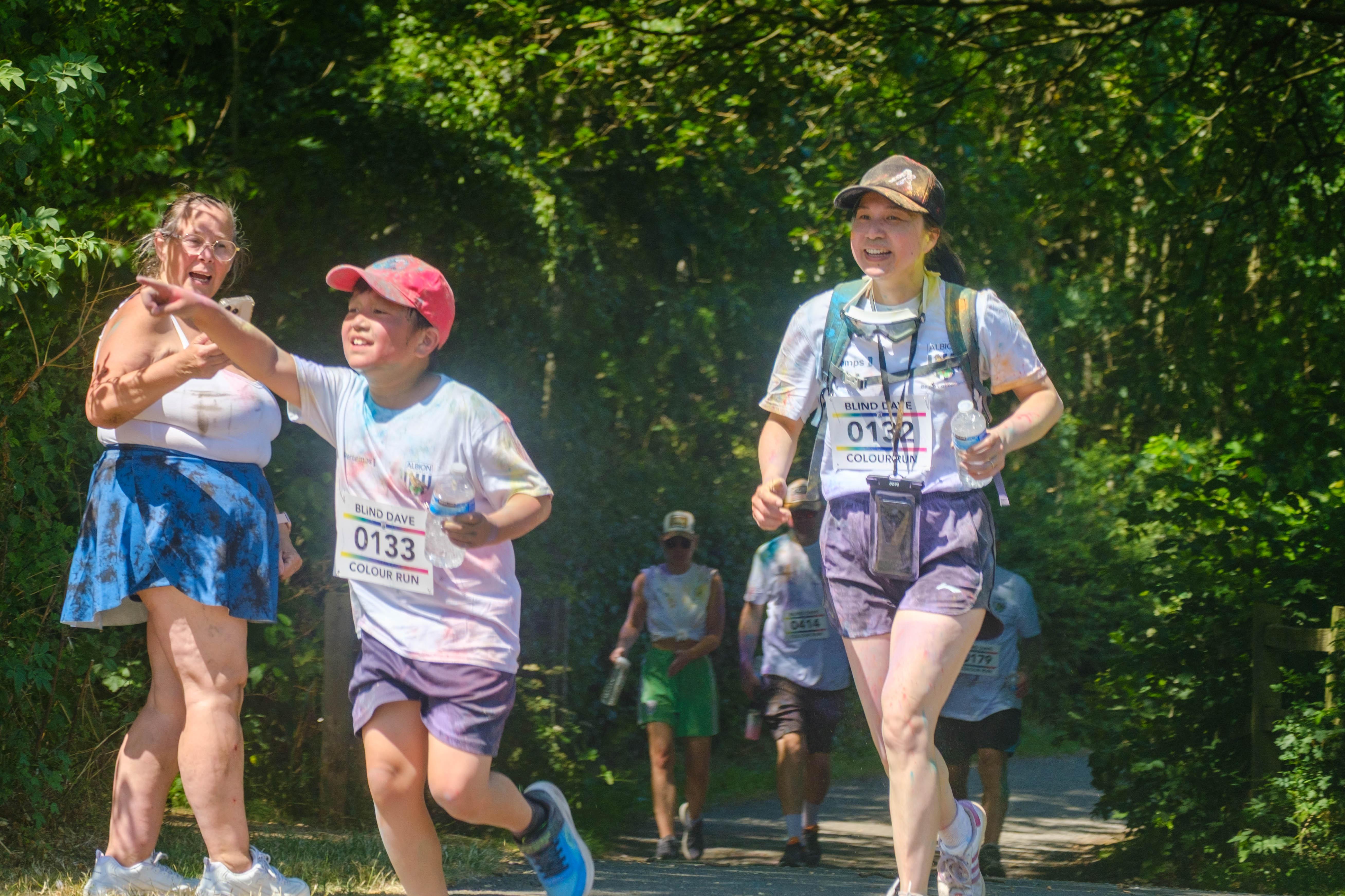 Son and Mother heading to the stretch, as he points towards the finish line.