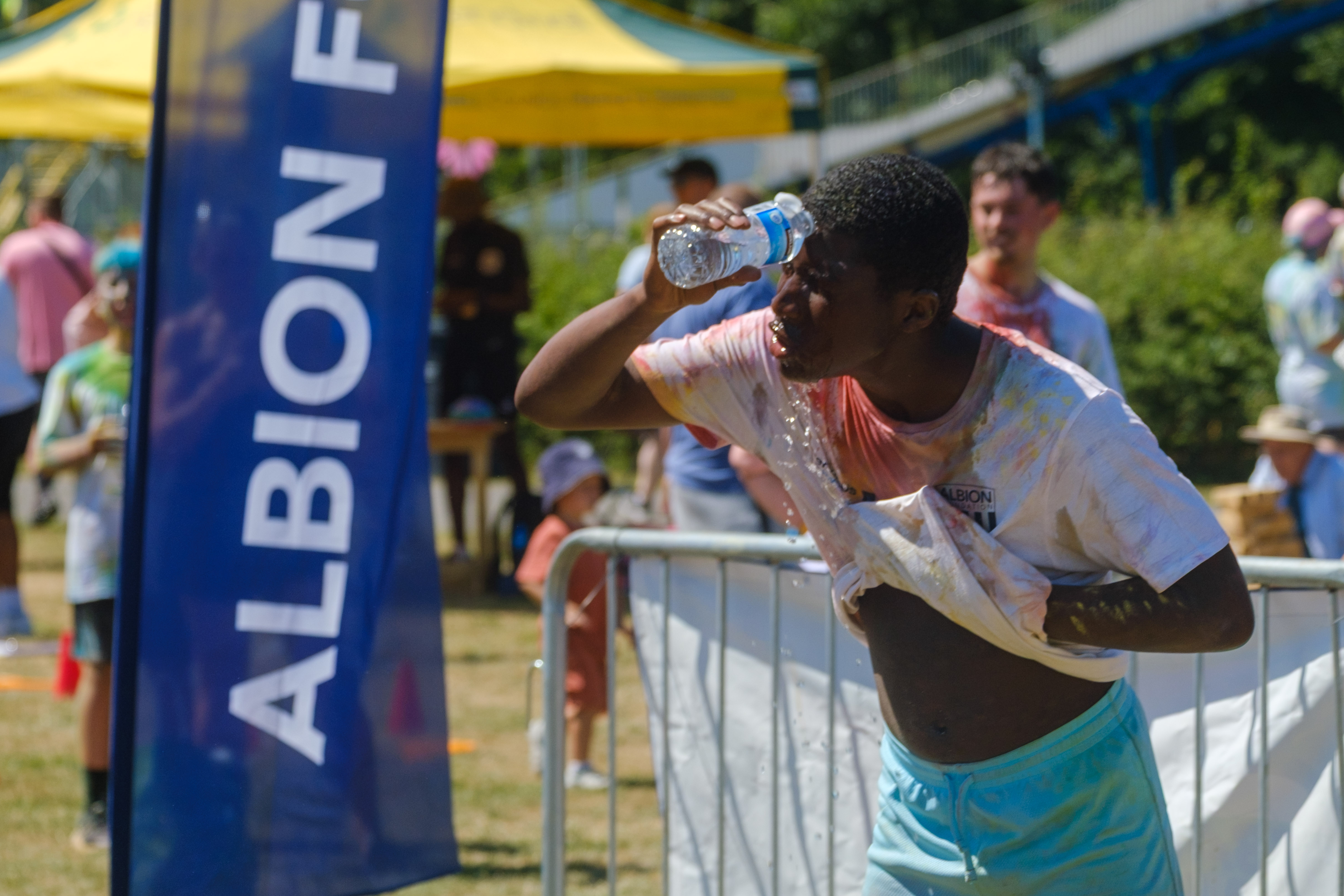 Participant pouring water over his face, after the run.