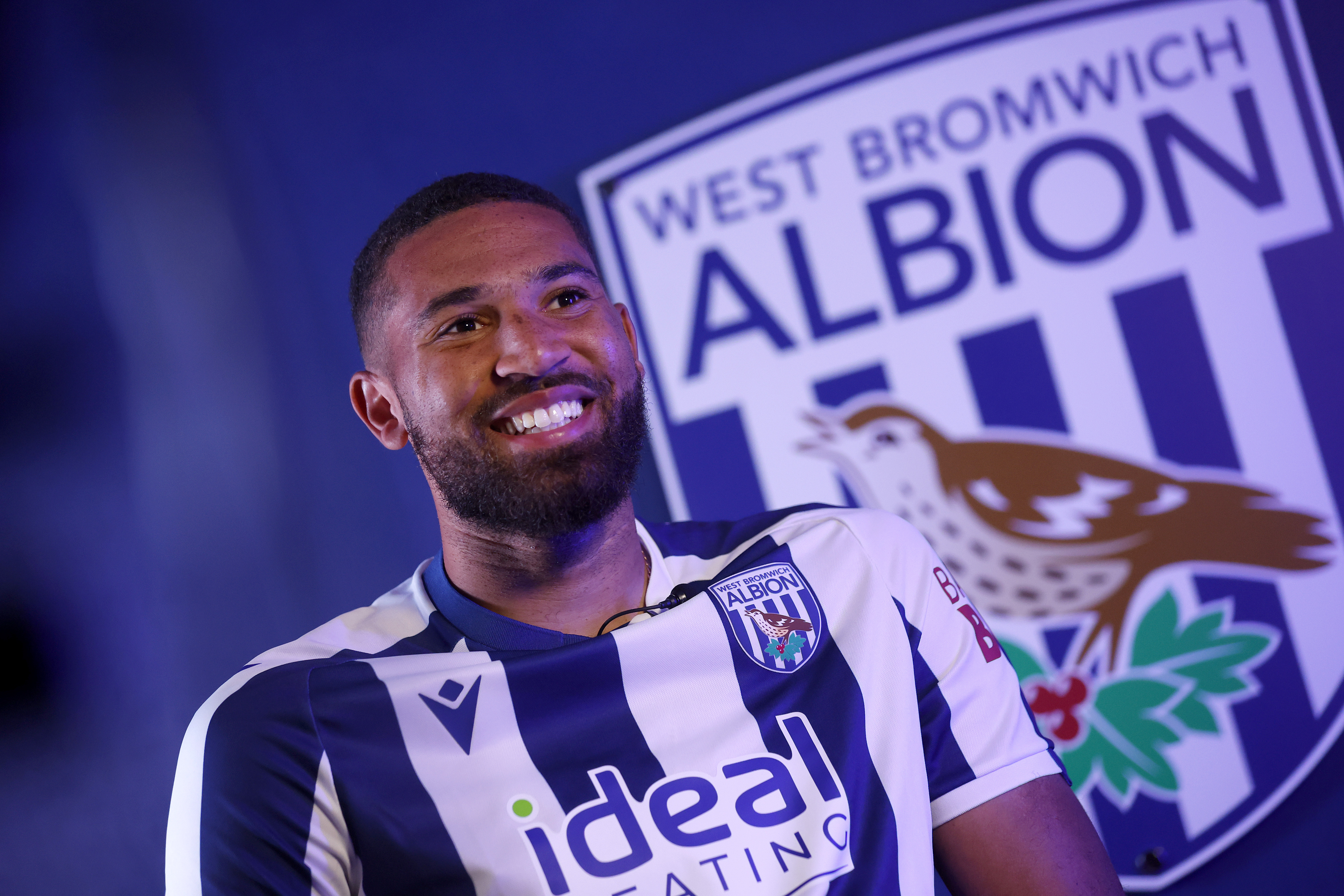 George Campbell smiling while sat in a home WBA shirt being interviewed by WBA TV in front of a big WBA badge