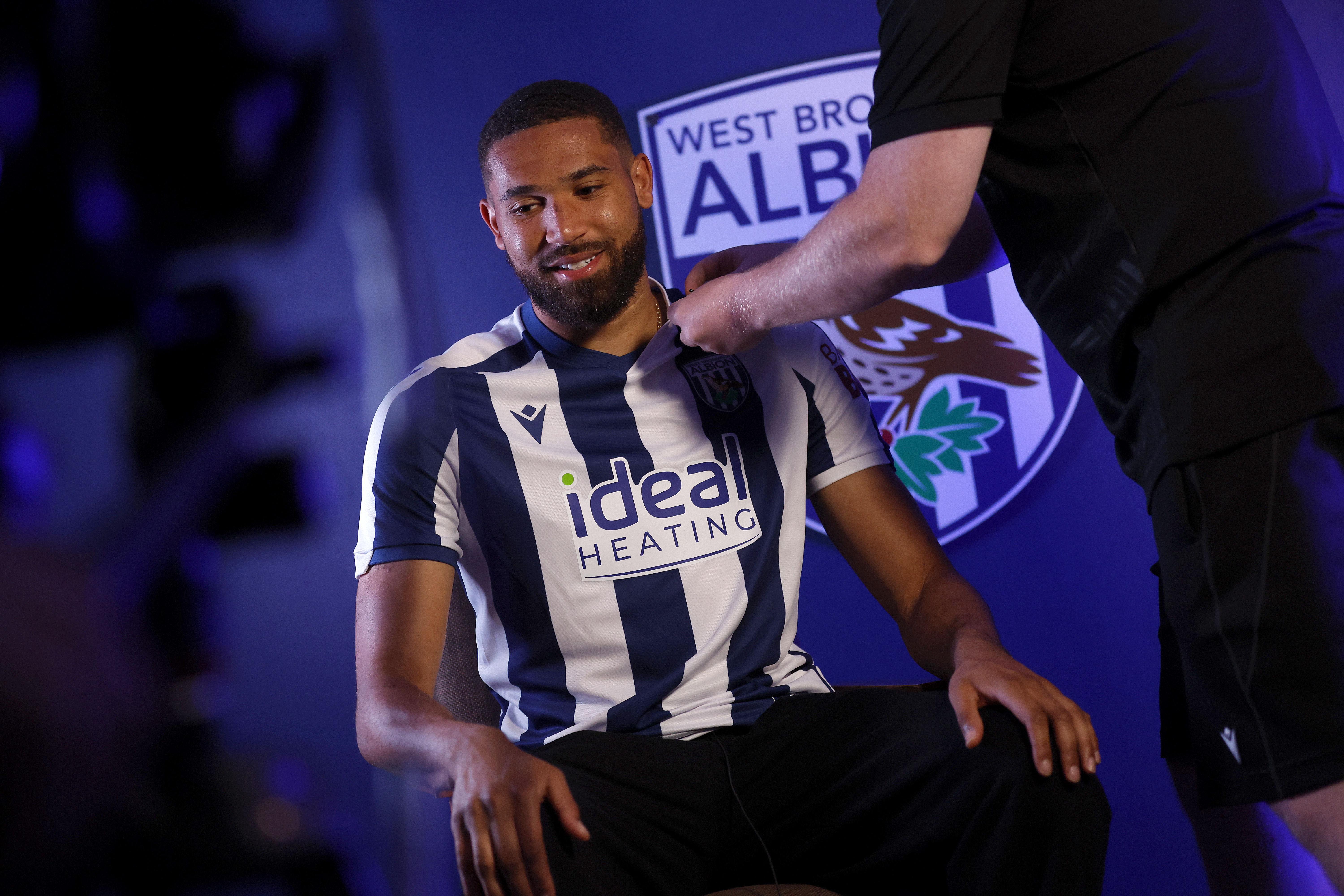 George Campbell sat in a chair in a home WBA shirt having a microphone attached to his top